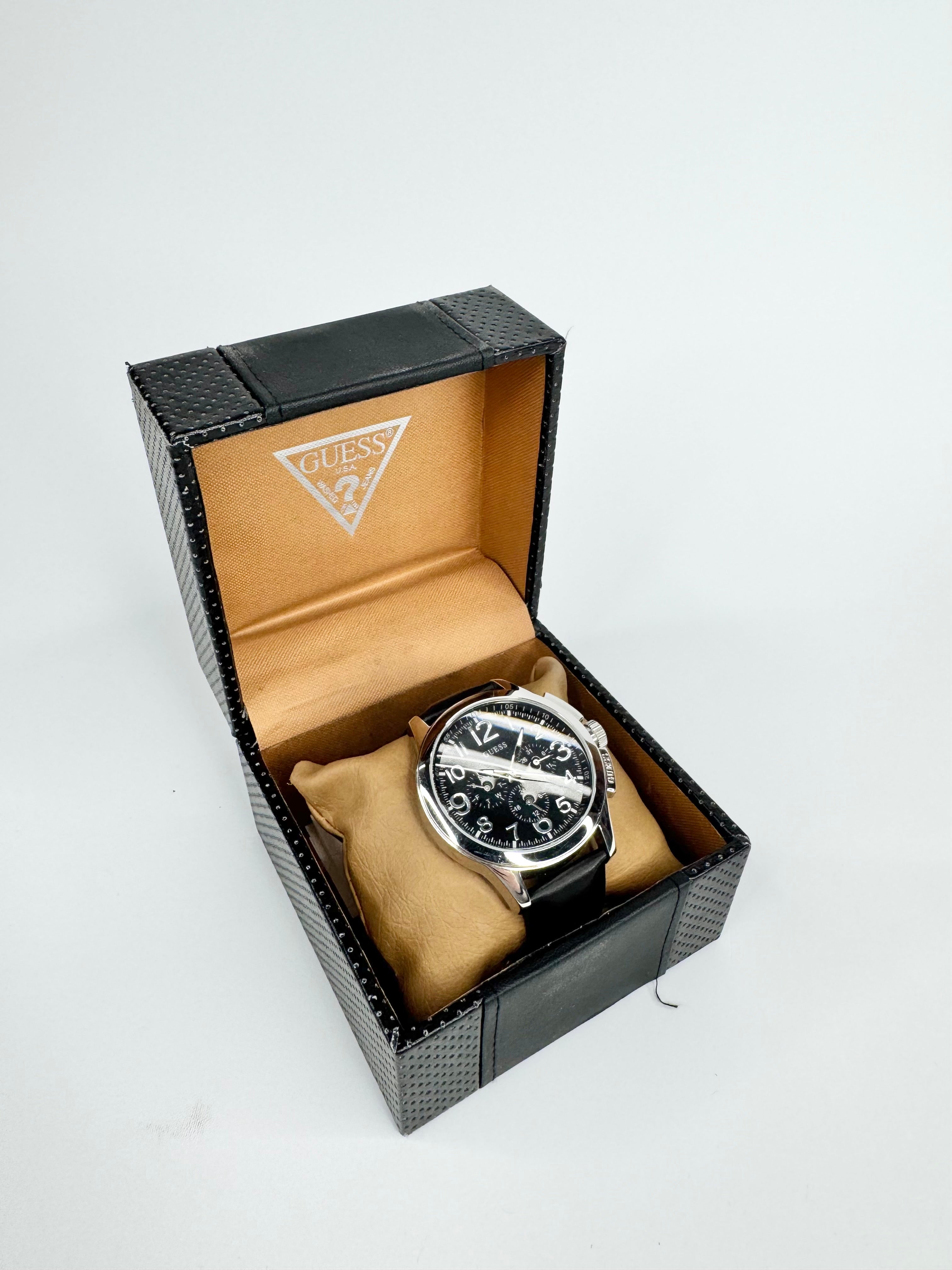 Black watch in a Guess branded box on a white background