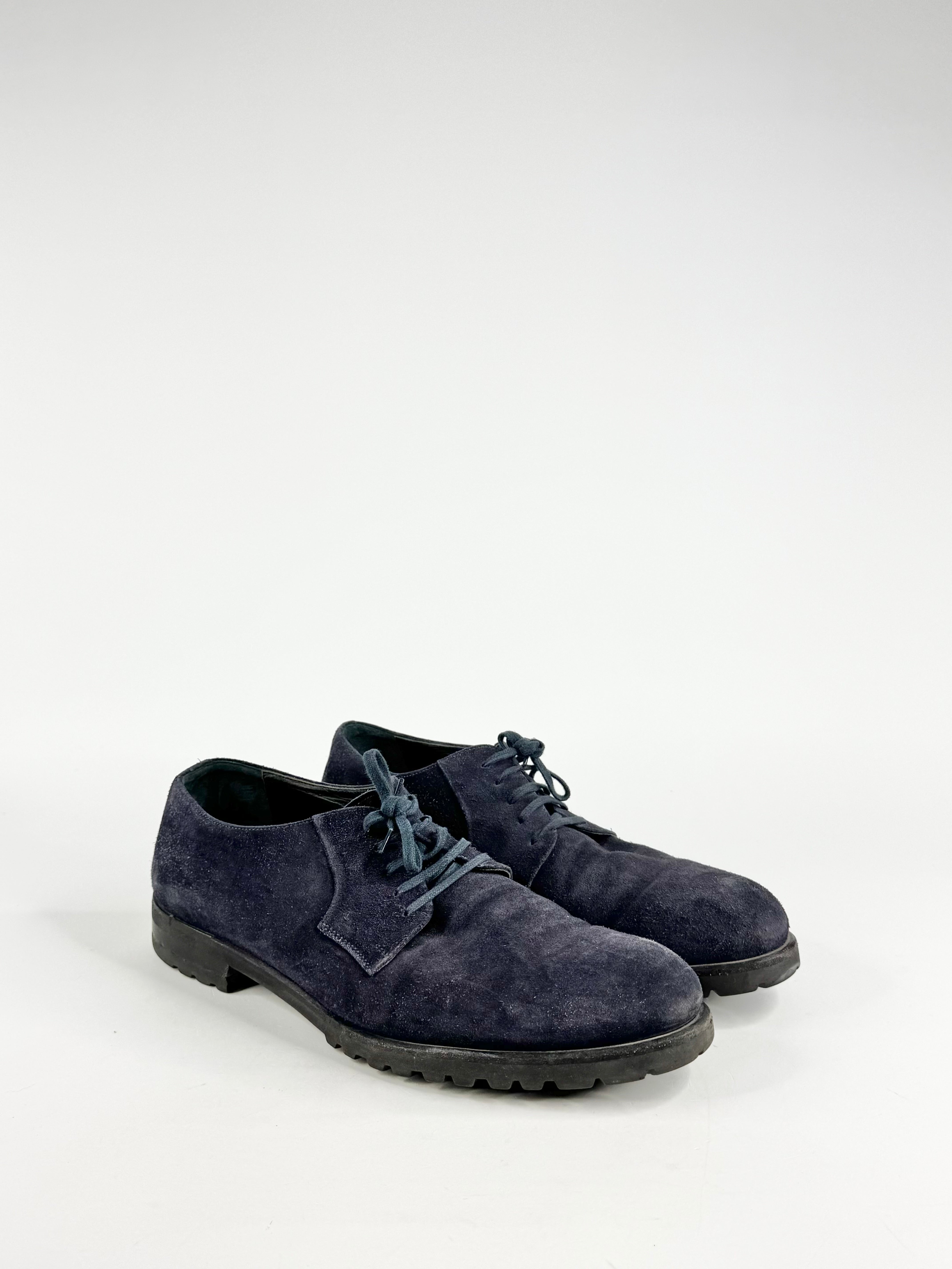 Pair of navy blue suede shoes on a white background