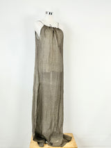 A long maxi beach dress displayed on a mannequin, featuring a halter neck and fine string ties at the front.