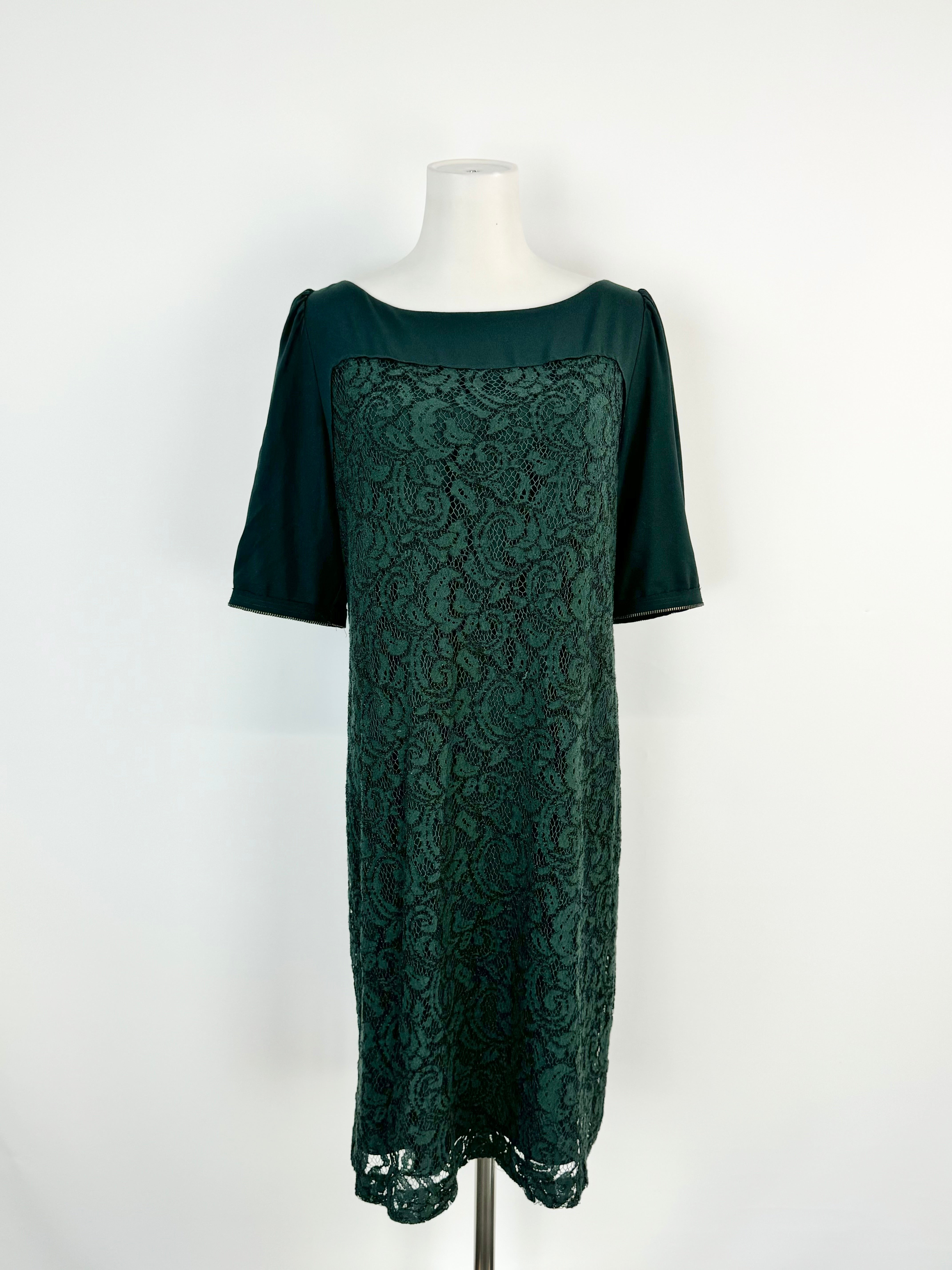 A forest green knee-length dress with half-length sleeves and a lace panel, displayed on a mannequin.