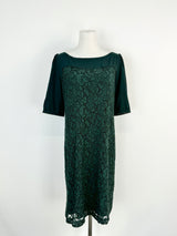 A forest green knee-length dress with half-length sleeves and a lace panel, displayed on a mannequin.