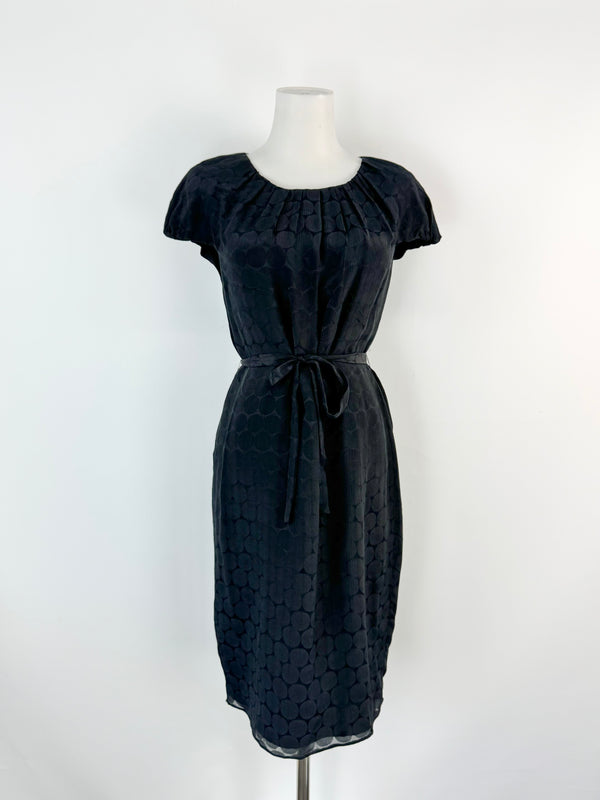 Black patterned dress on a mannequin against a white background