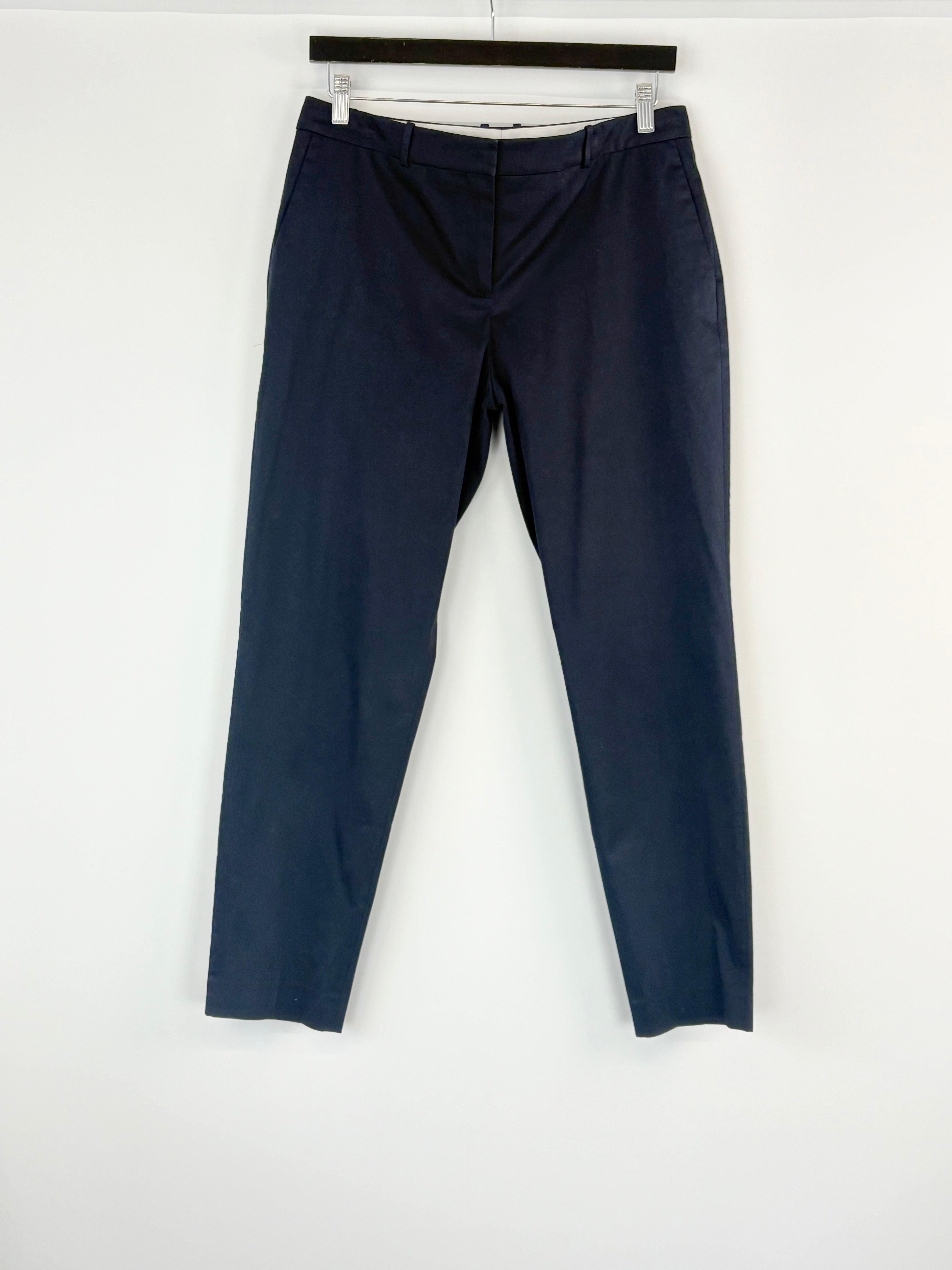 Navy blue pants hanging on a white background