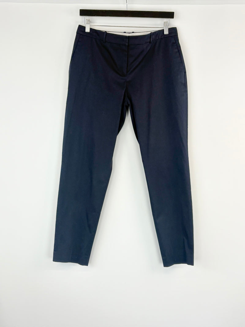 Navy blue pants hanging on a white background