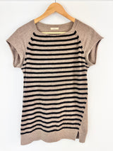 Striped shirt with beige sleeves on a hanger against a white background