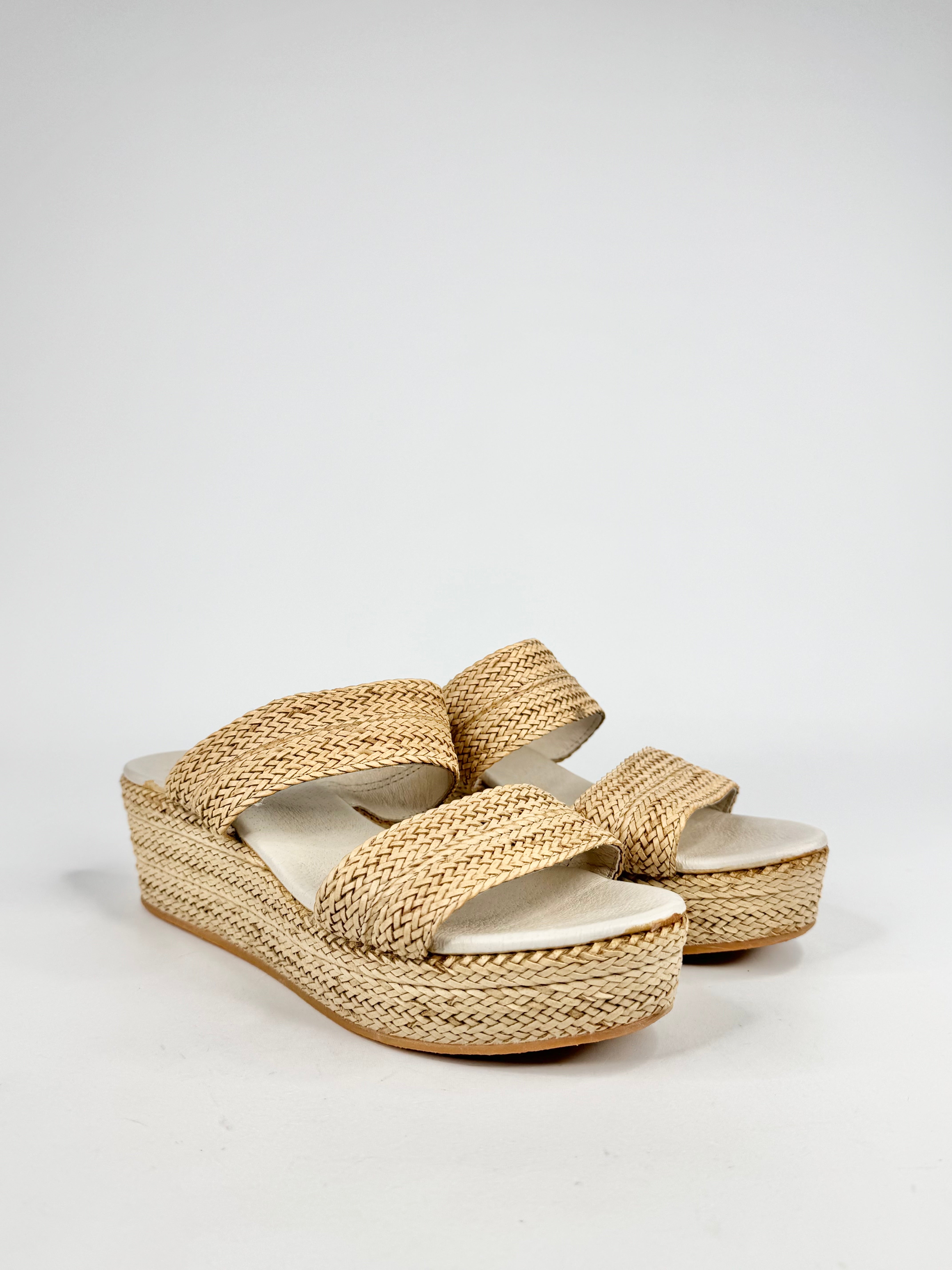 Pair of woven sandals on a light gray background