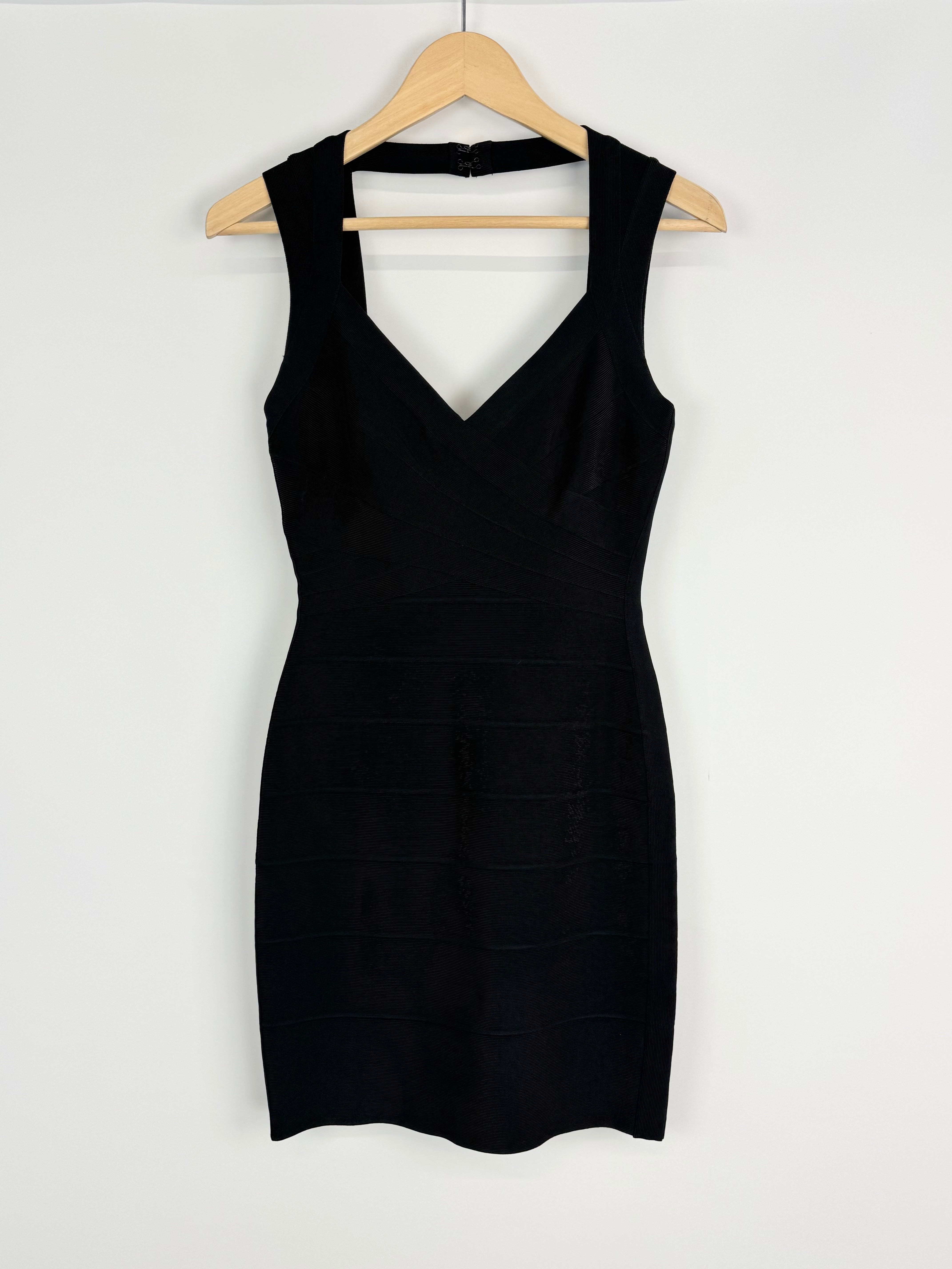 Black dress on a wooden hanger against a white background