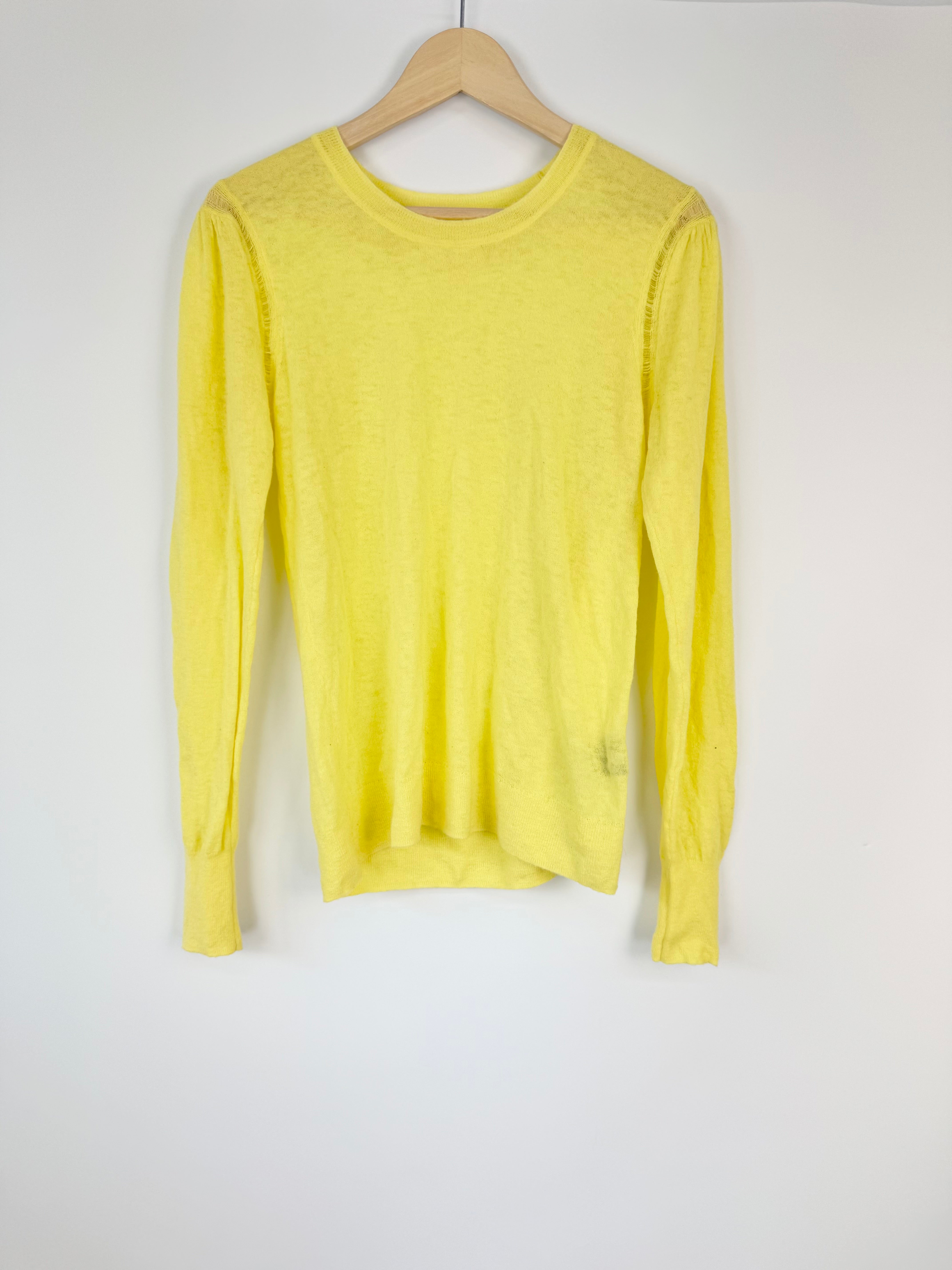 Yellow long-sleeve shirt on a wooden hanger against a white background