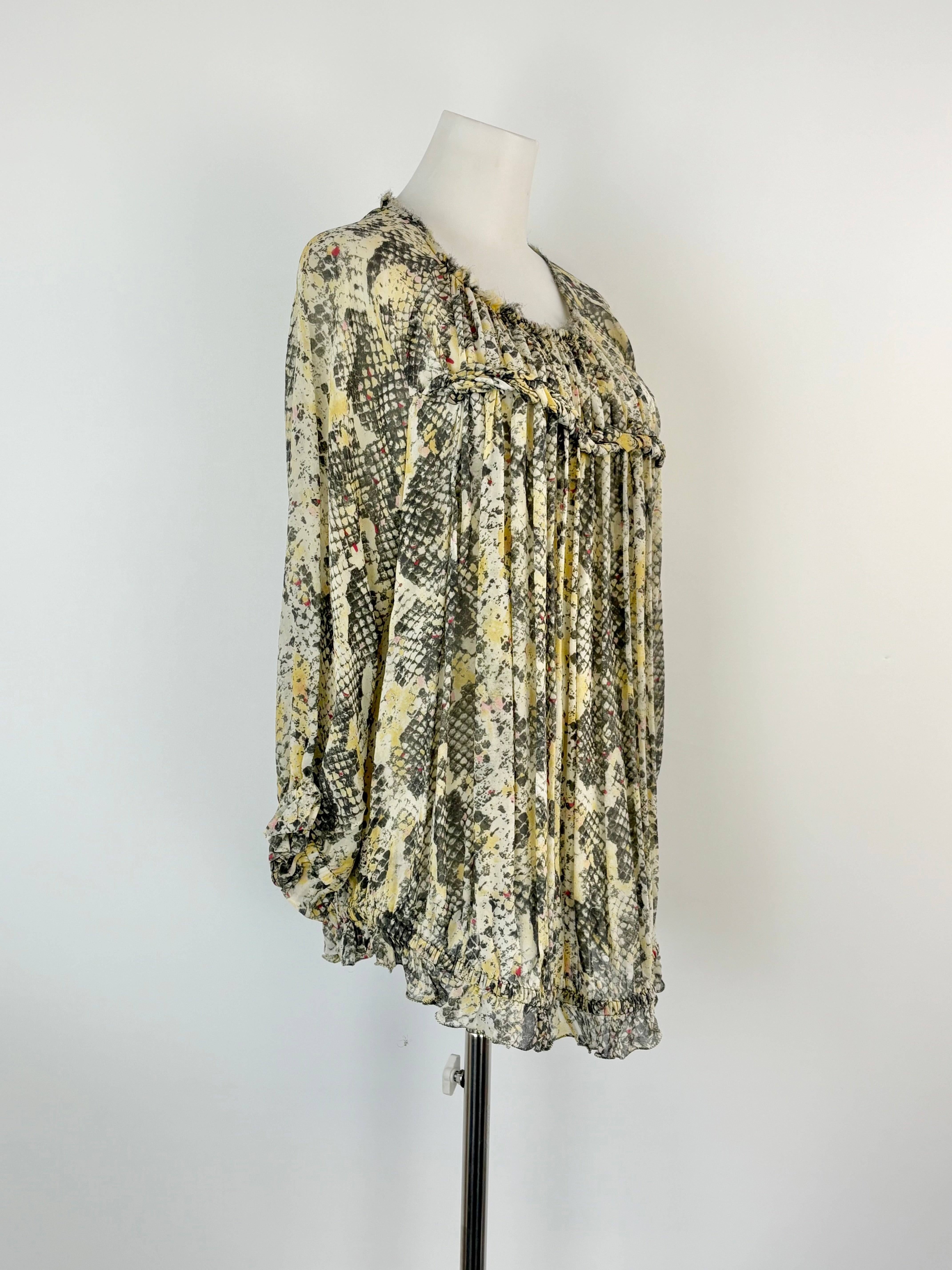 Mannequin wearing a patterned blouse against a white background