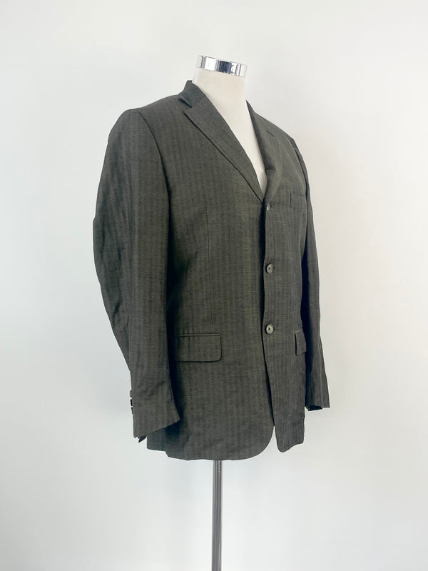 Charcoal wool and linen blend sports blazer on a mannequin, displaying the front view with three buttons and the jacket's details.