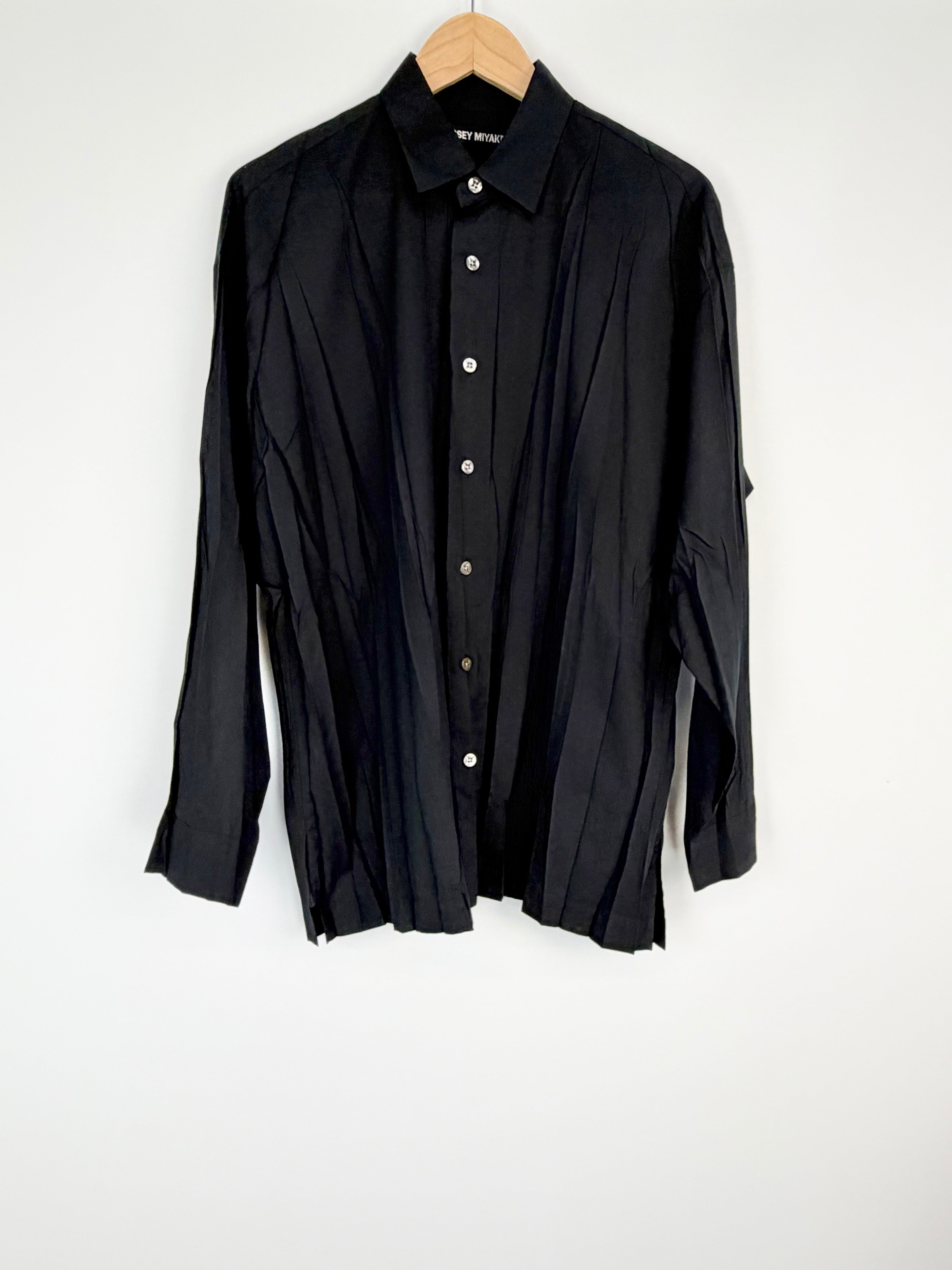 Black shirt on a hanger against a white background