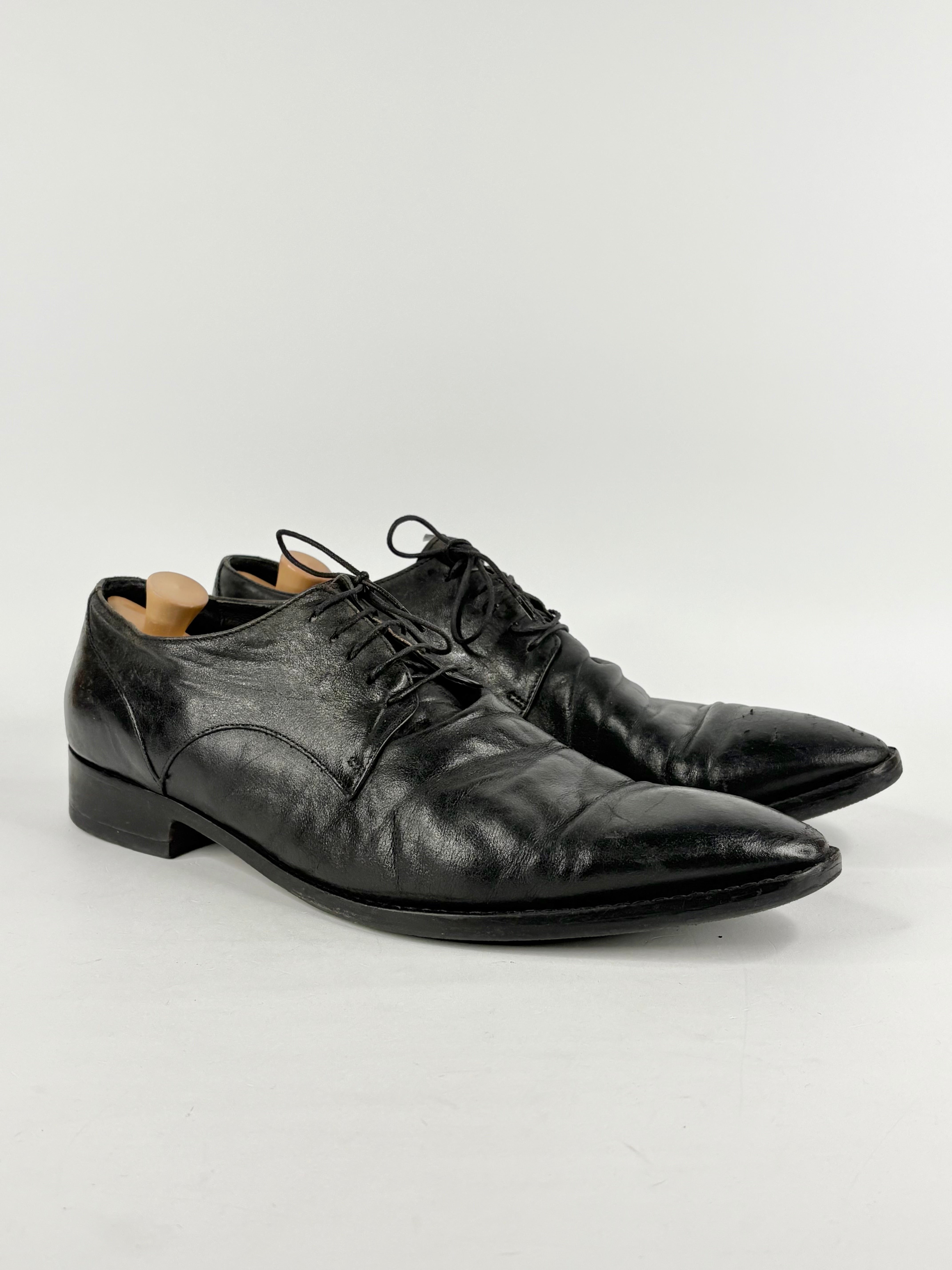 Pair of black leather dress shoes on a white background