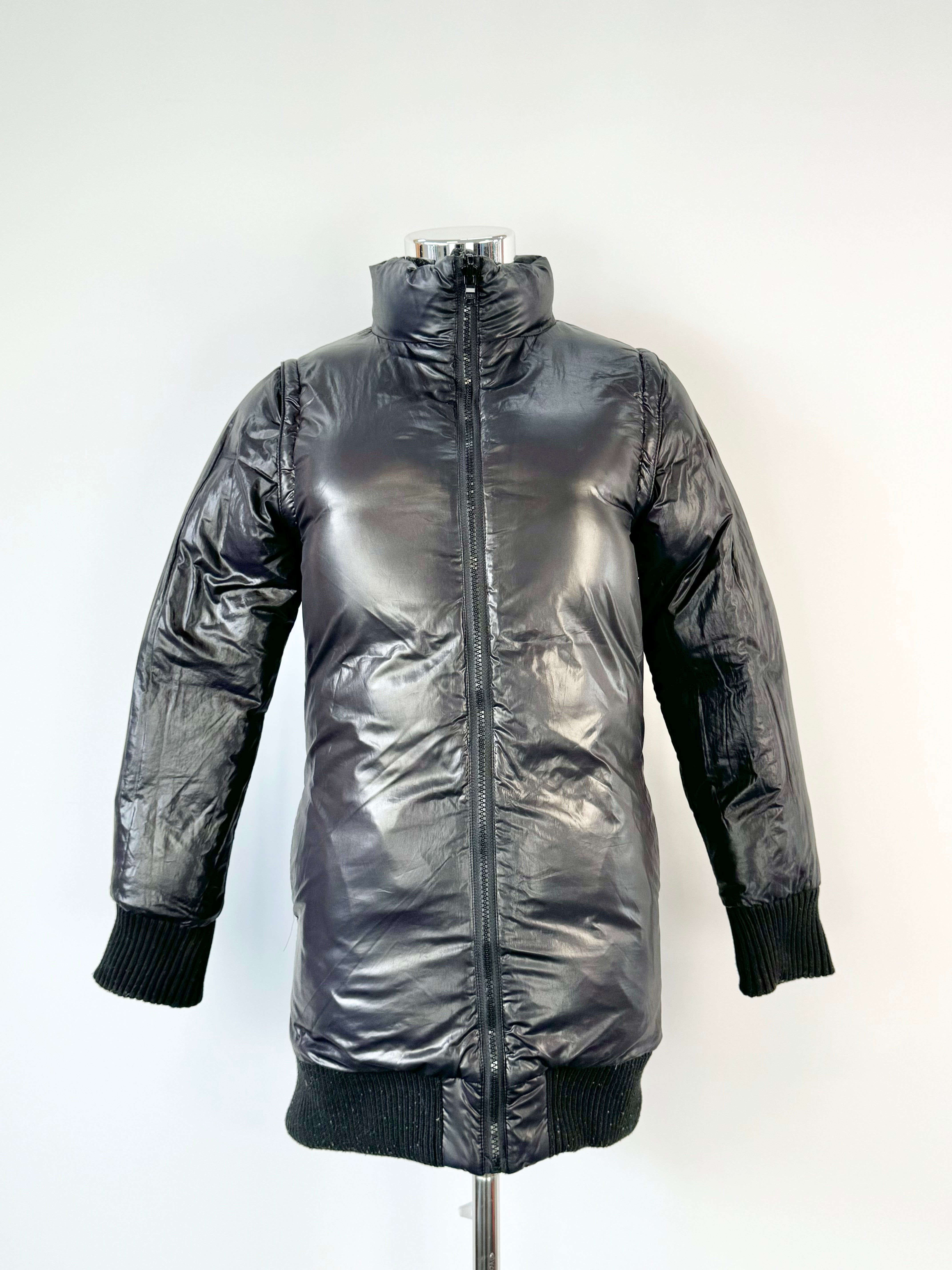 A reversible black puffa jacket with a herringbone wool blend on one side, displayed on a mannequin.