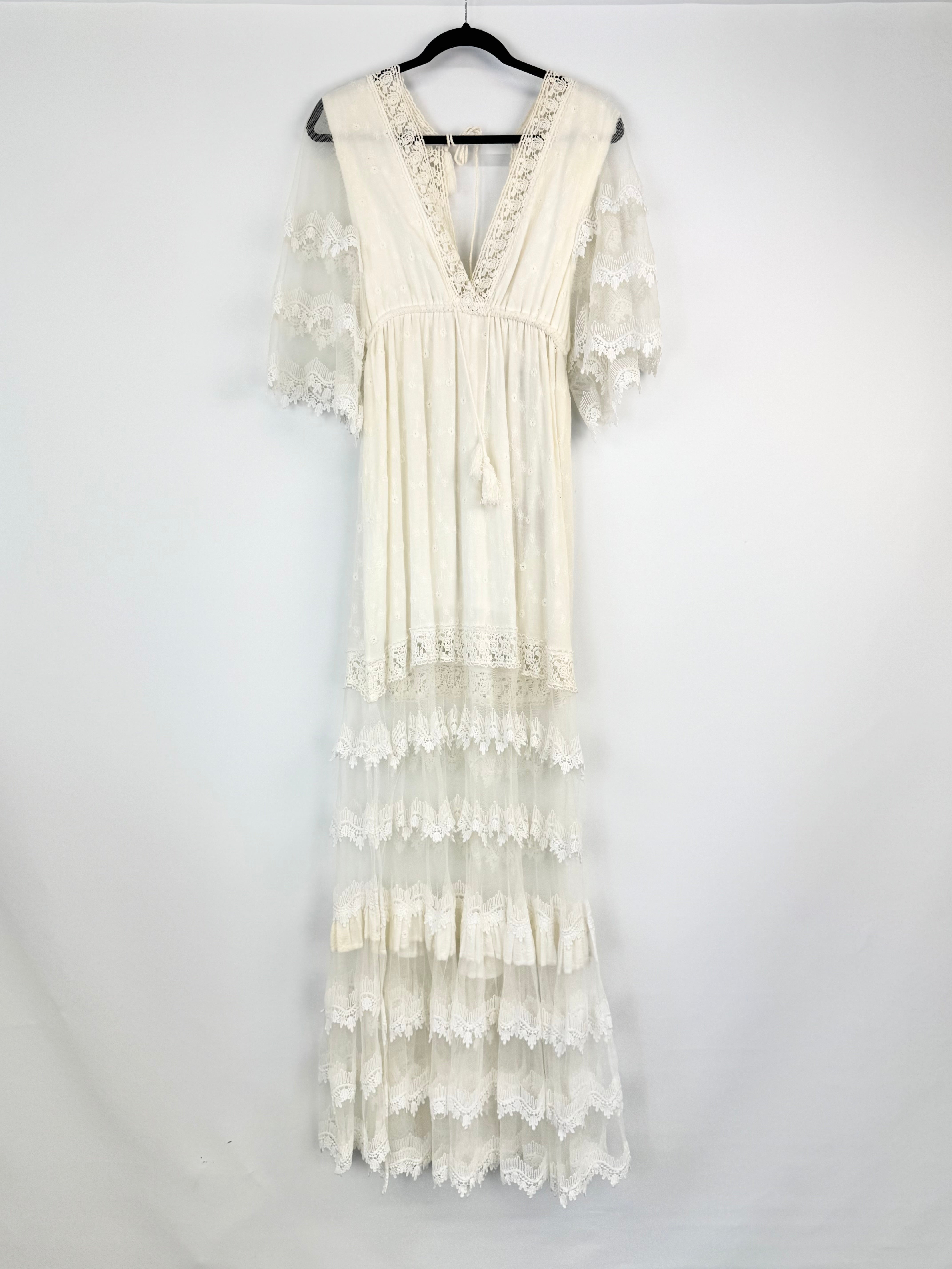 White lace dress on a hanger against a white background