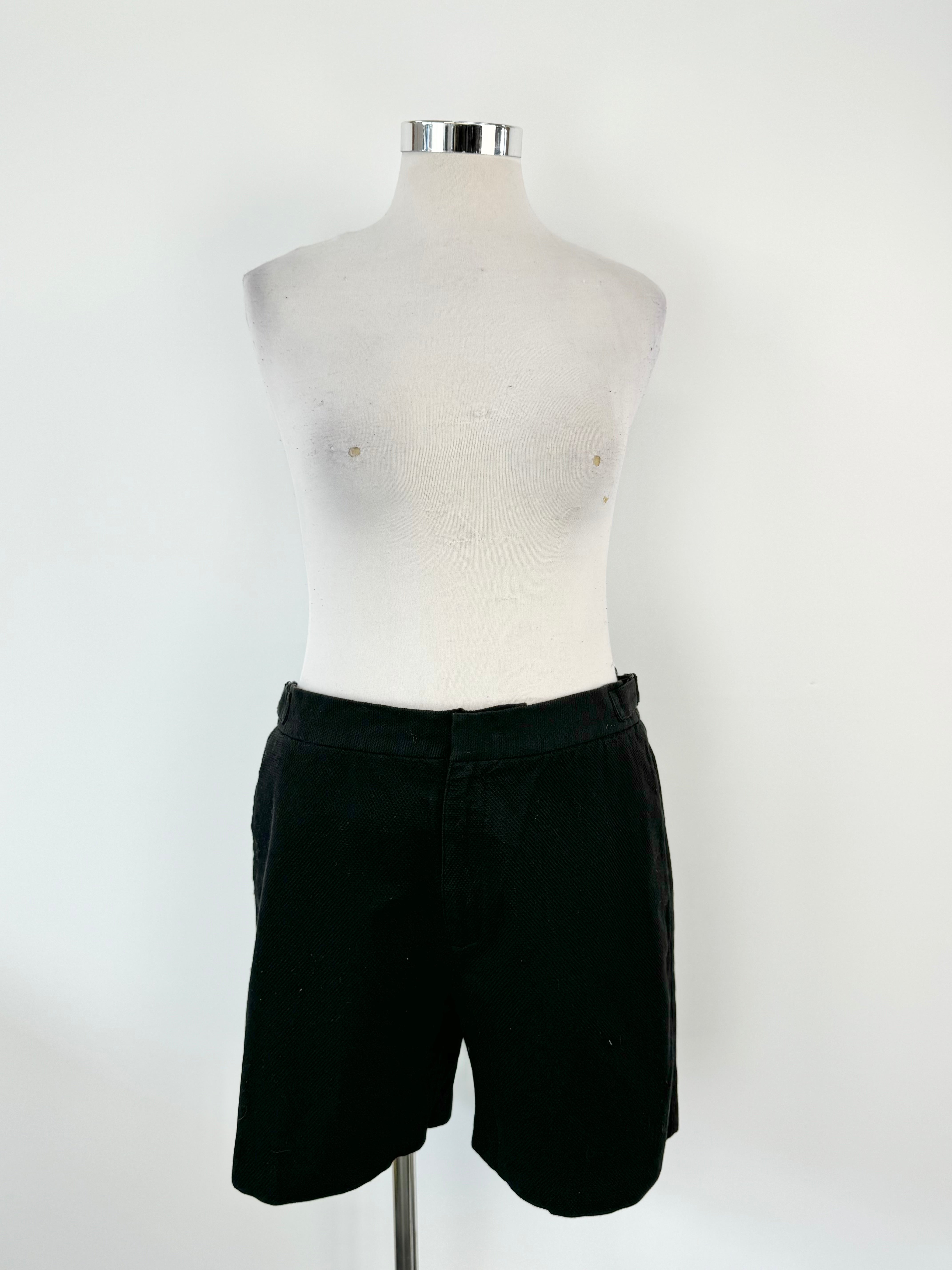 A pair of black shorts displayed on a male mannequin, with the brand tags still attached.