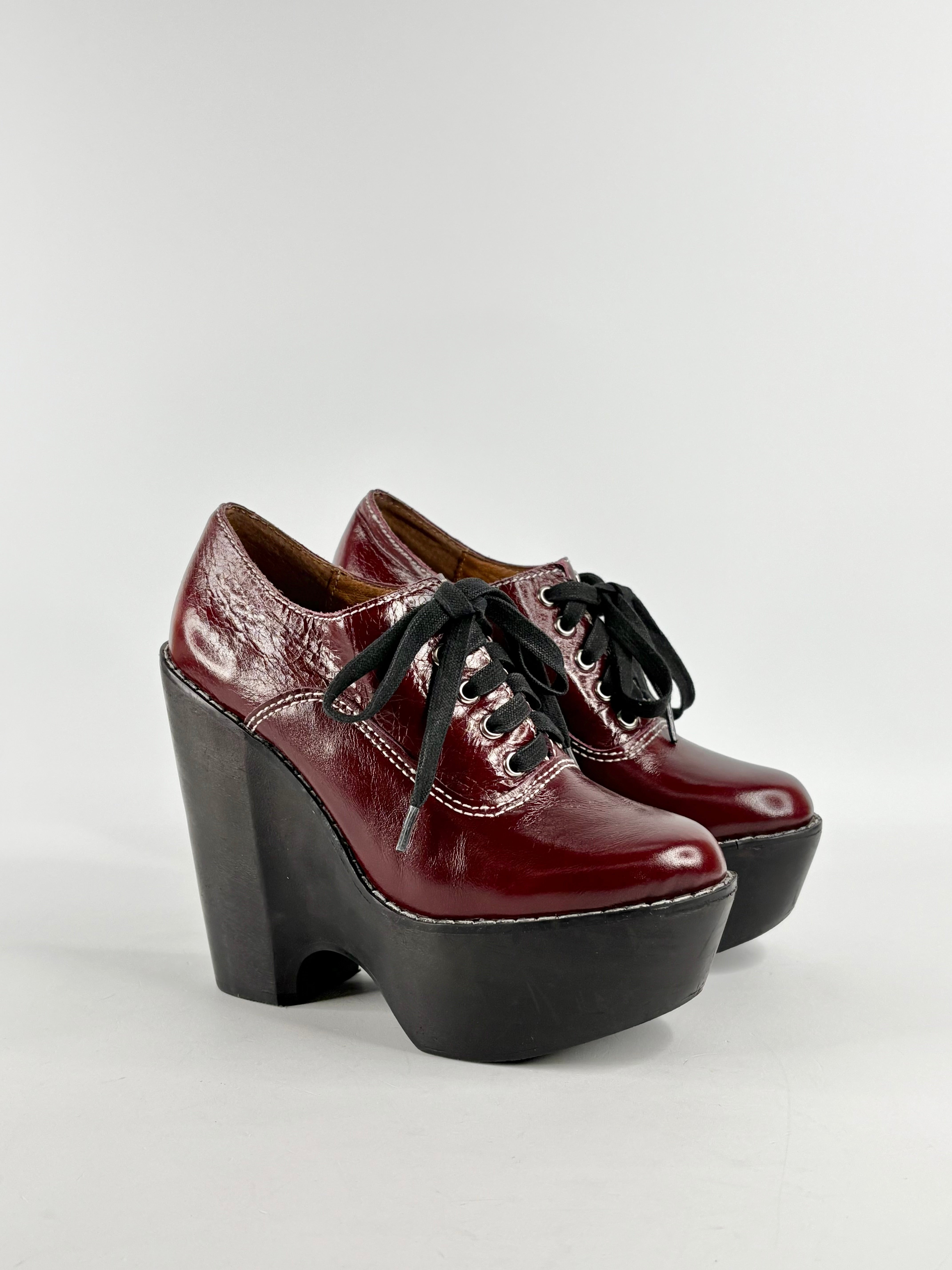 A pair of cherry red leather lace-up platform shoes with black heels.