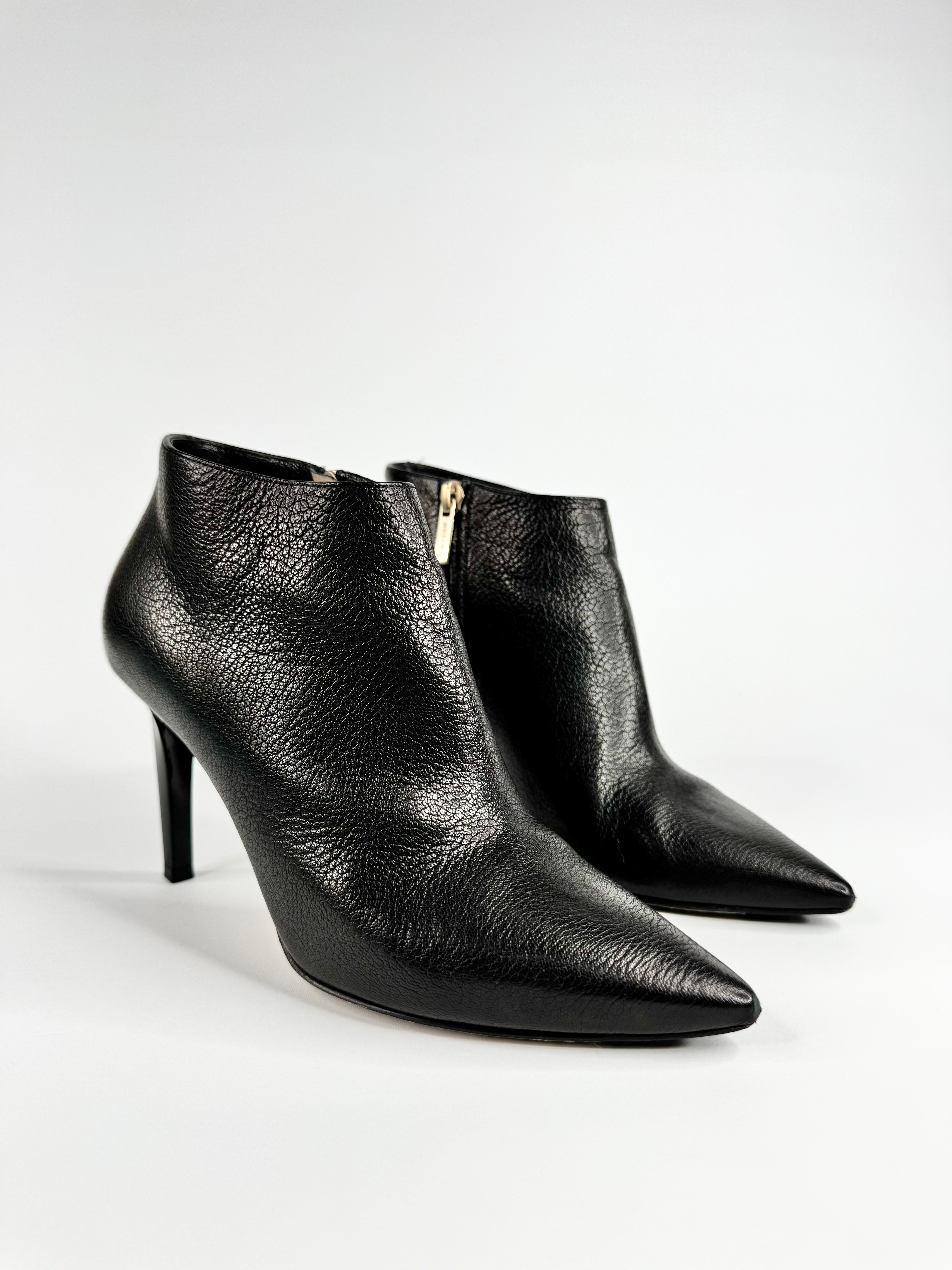 Black leather ankle boots with a zipper on a white background