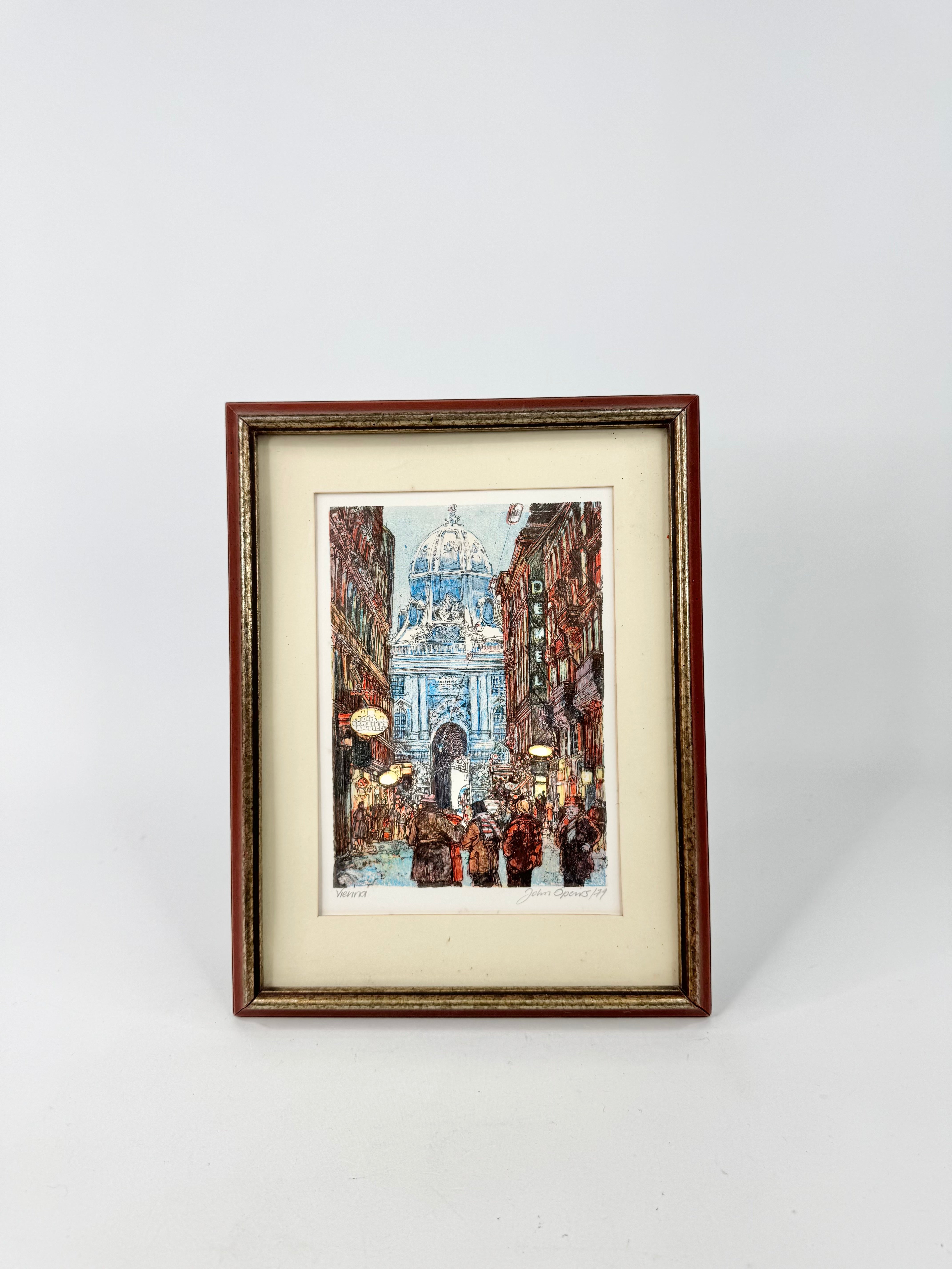 Framed artwork of a city street scene with a large building in the background on a white background