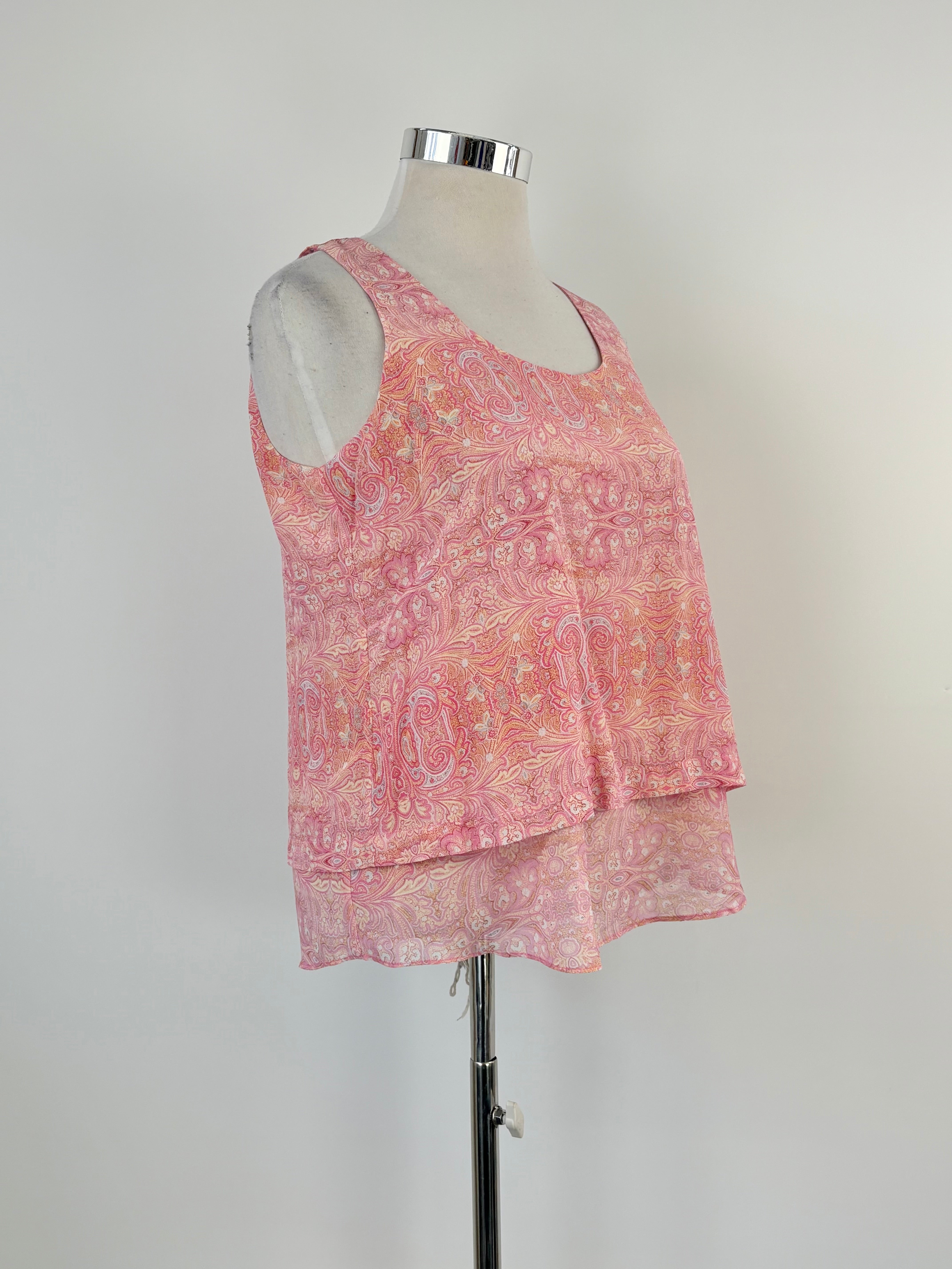 A pink sleeveless silk top with a paisley pattern, displayed on a mannequin.