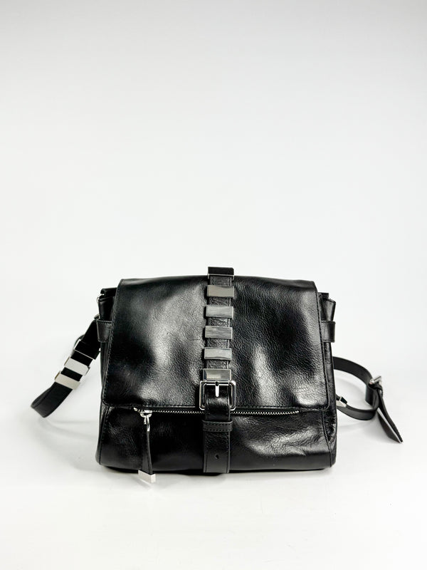 Black leather bag with silver buckles on a white background