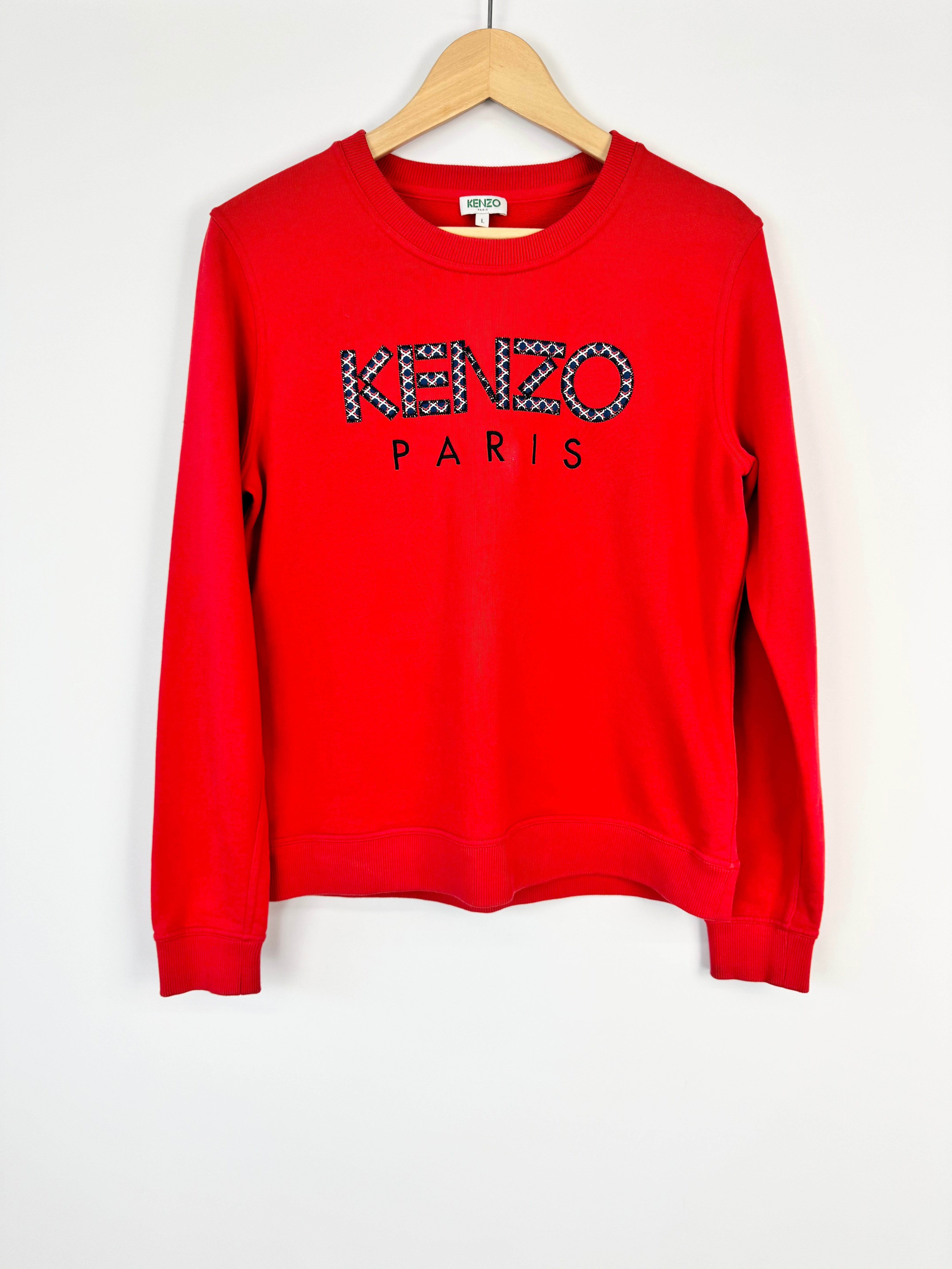 Red sweatshirt with 'Kenzo Paris' text on a white background