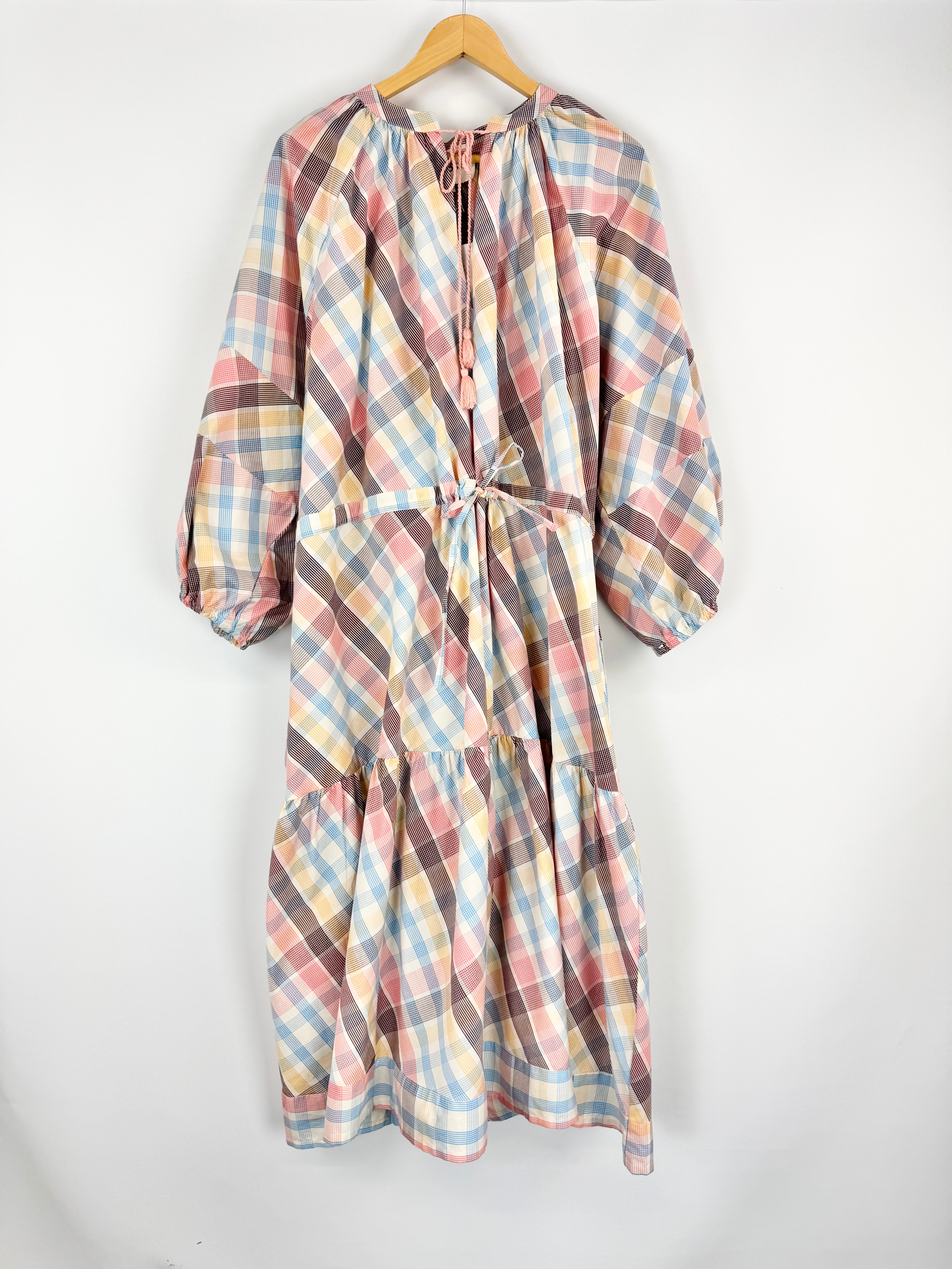 Plaid dress on a hanger against a white background