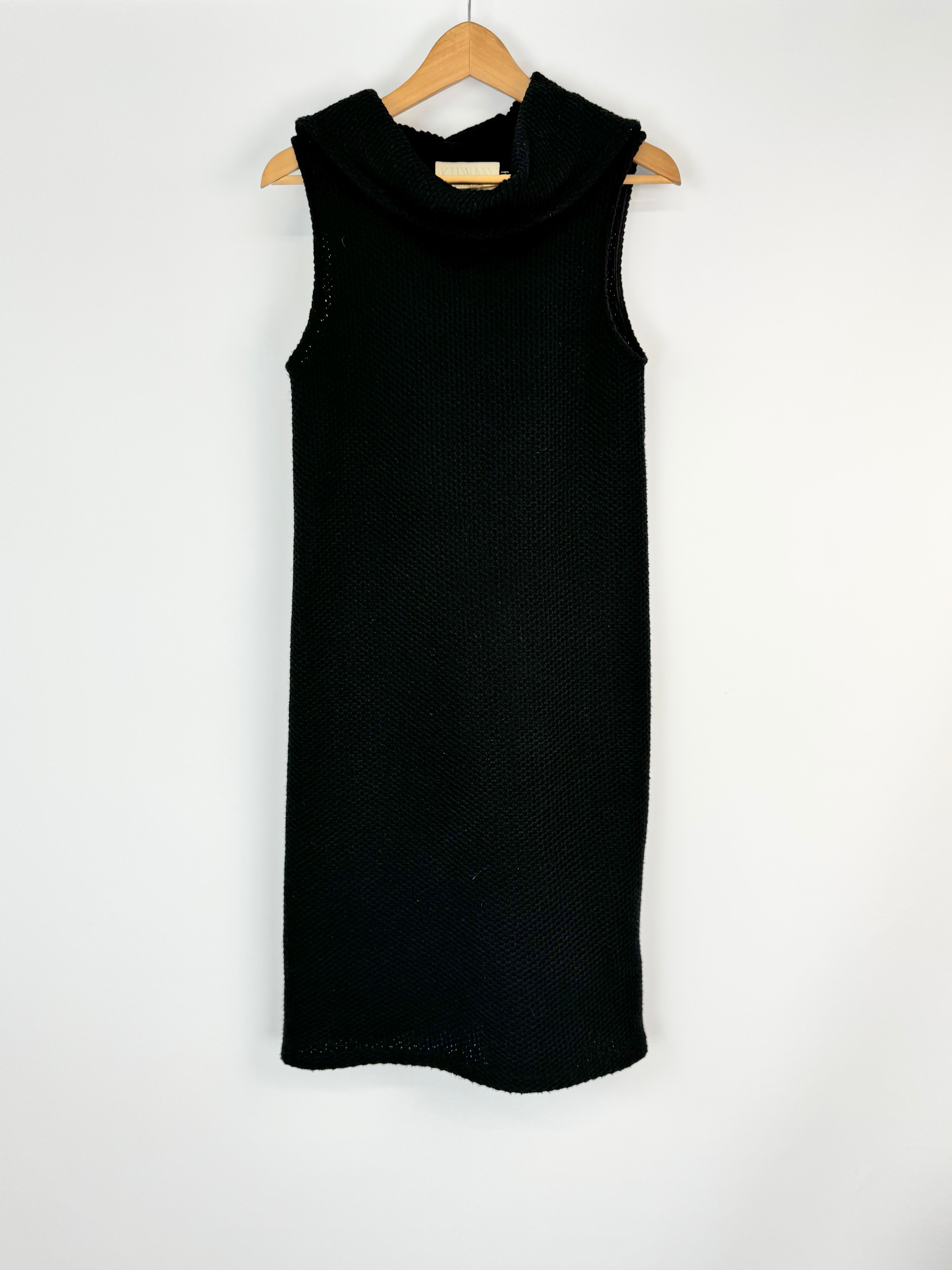 Black sleeveless dress on a wooden hanger against a white background