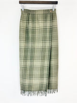 Green plaid skirt with fringe on a white background