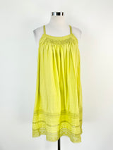 A Lee Mathews apple green linen shift dress displayed on a mannequin, featuring medium wide straps, lace trim, and a shirred section at the bust.