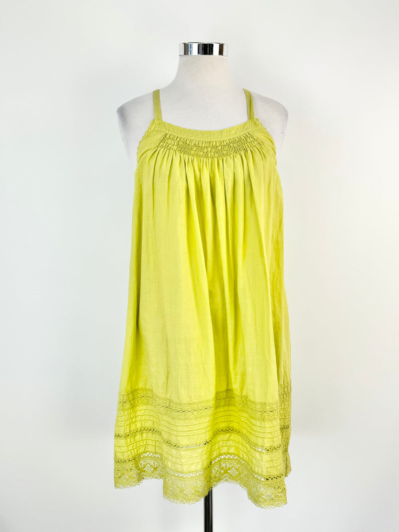 A Lee Mathews apple green linen shift dress displayed on a mannequin, featuring medium wide straps, lace trim, and a shirred section at the bust.