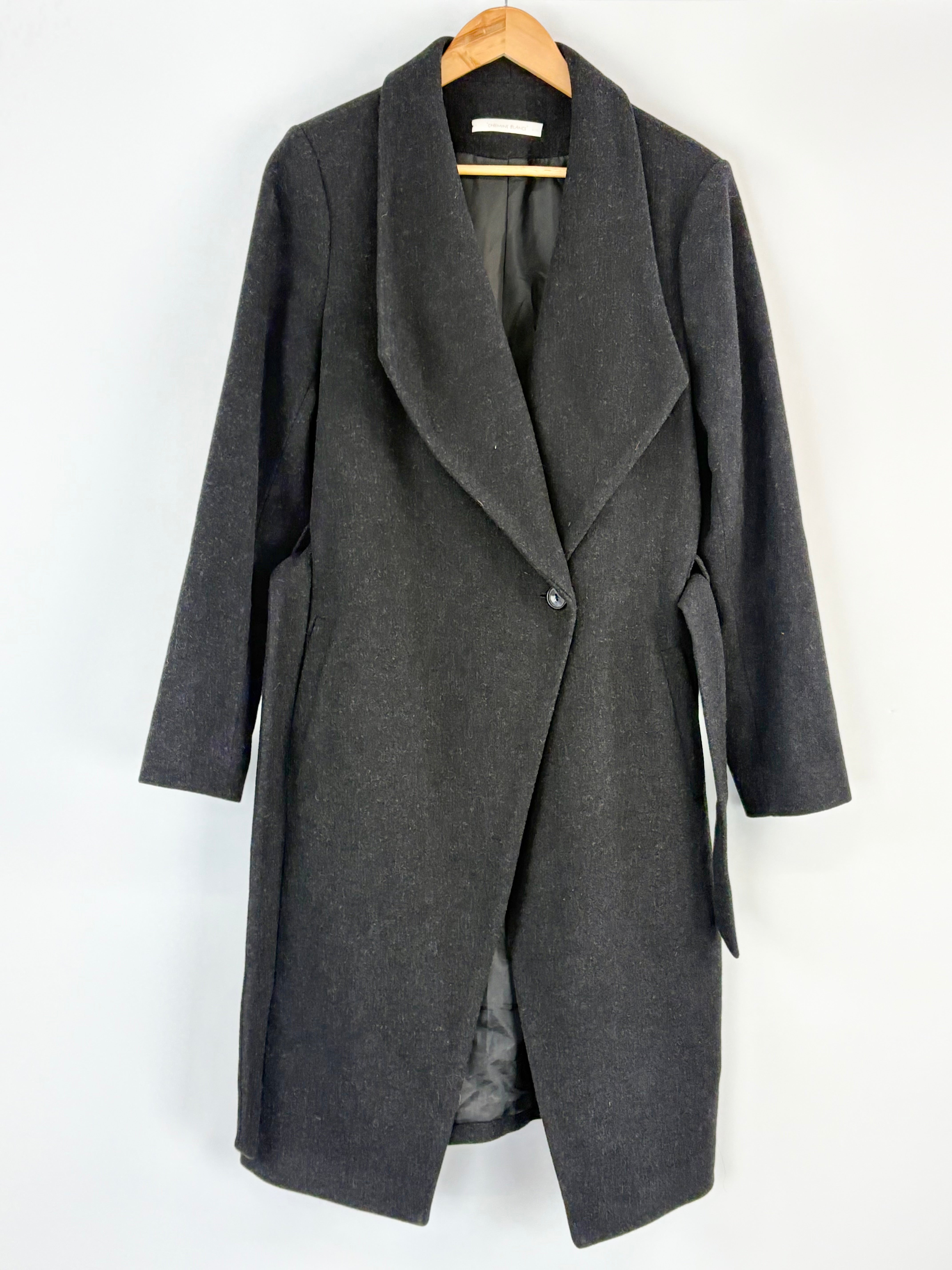 Black coat on a hanger against a white background