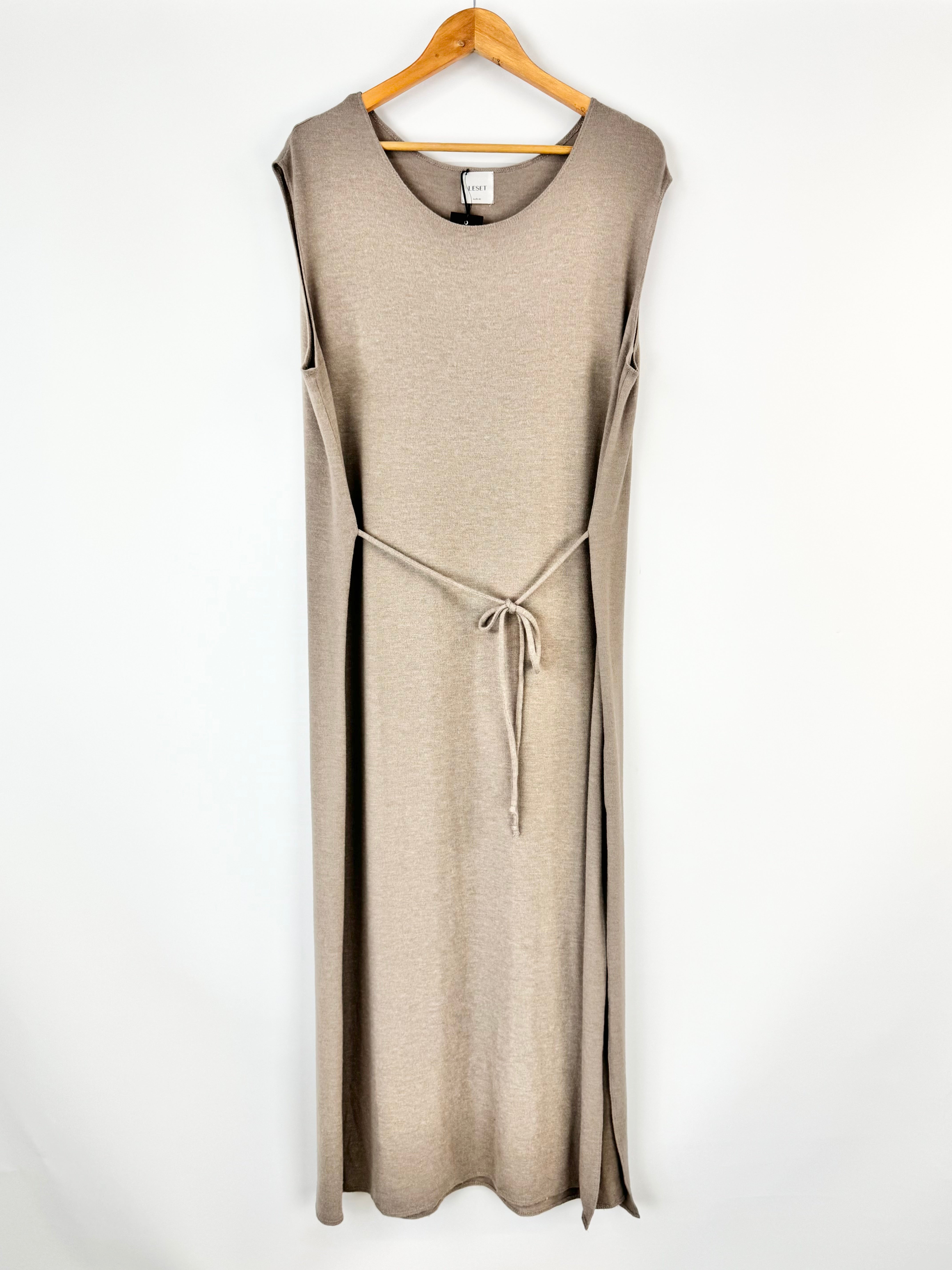 Beige sleeveless dress on a hanger against a white background
