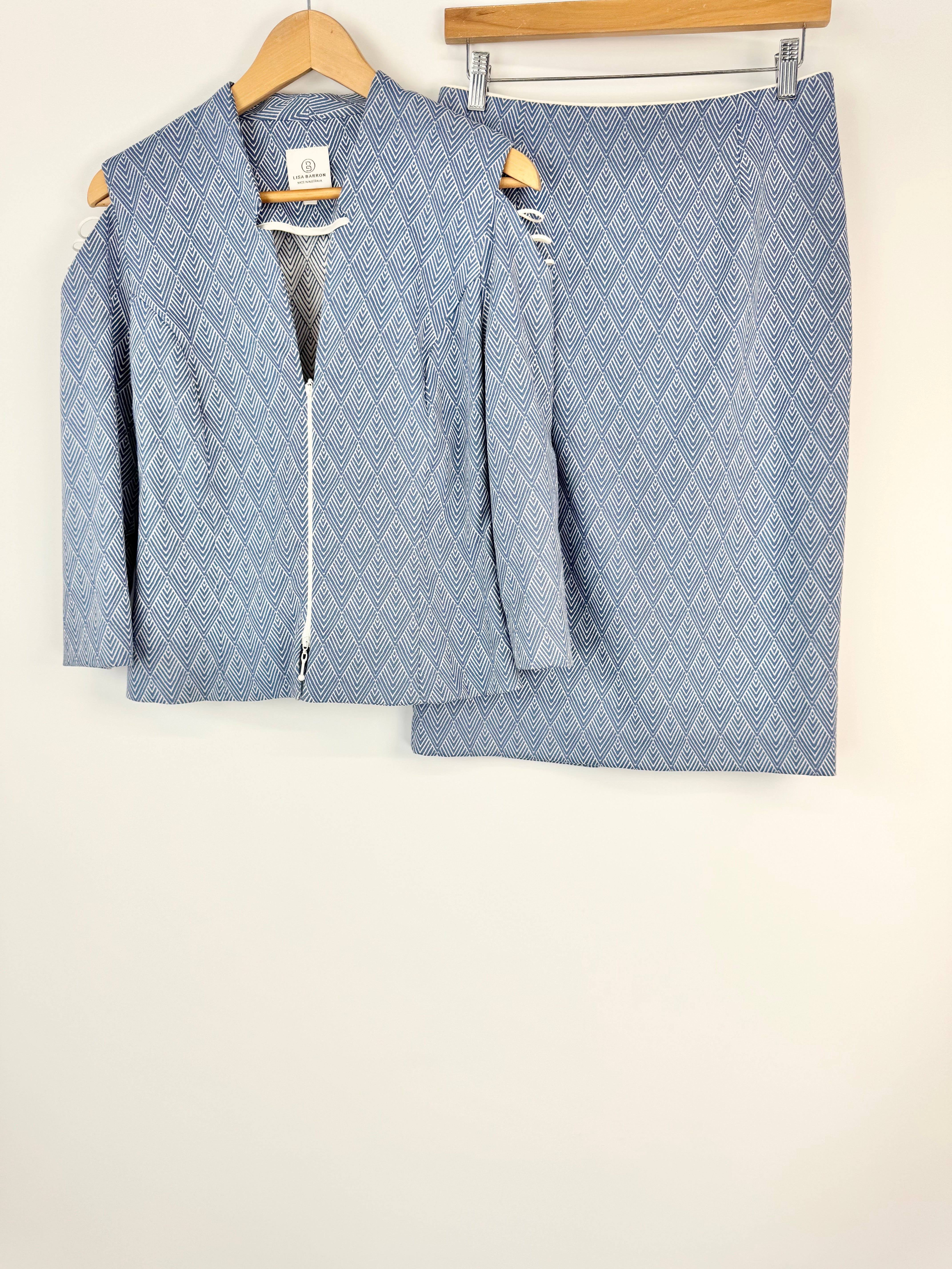 Blue diamond patterned jacket and skirt set on hangers against a white background