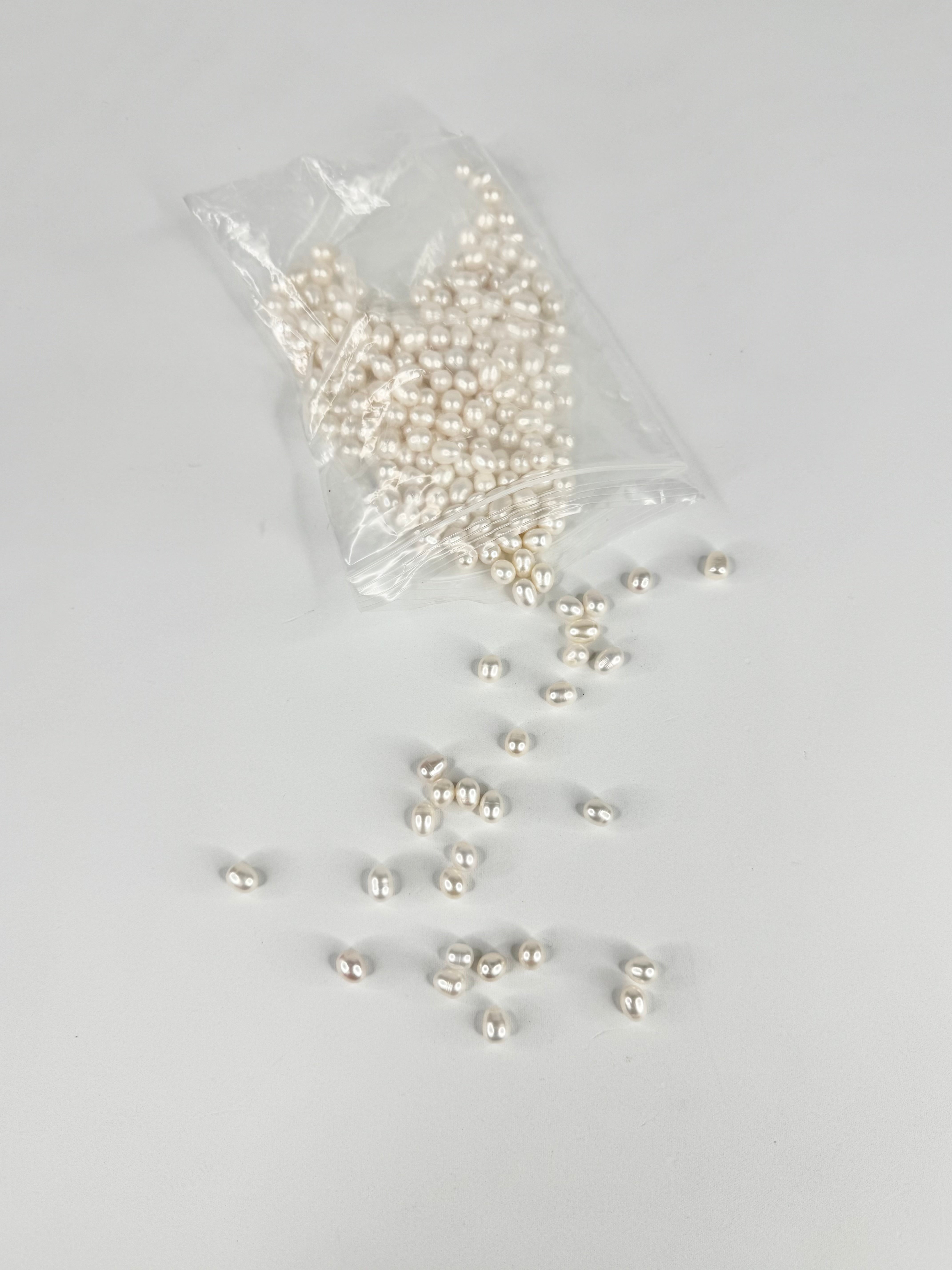 White pearls in a clear plastic bag on a gray background