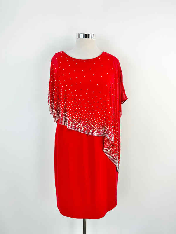 A red cocktail dress with silver sequin embellishments and a sheer built-in shawl, displayed on a mannequin.