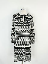 A black and white zig zag dress on a mannequin, with long sleeves and a wide striped waist.