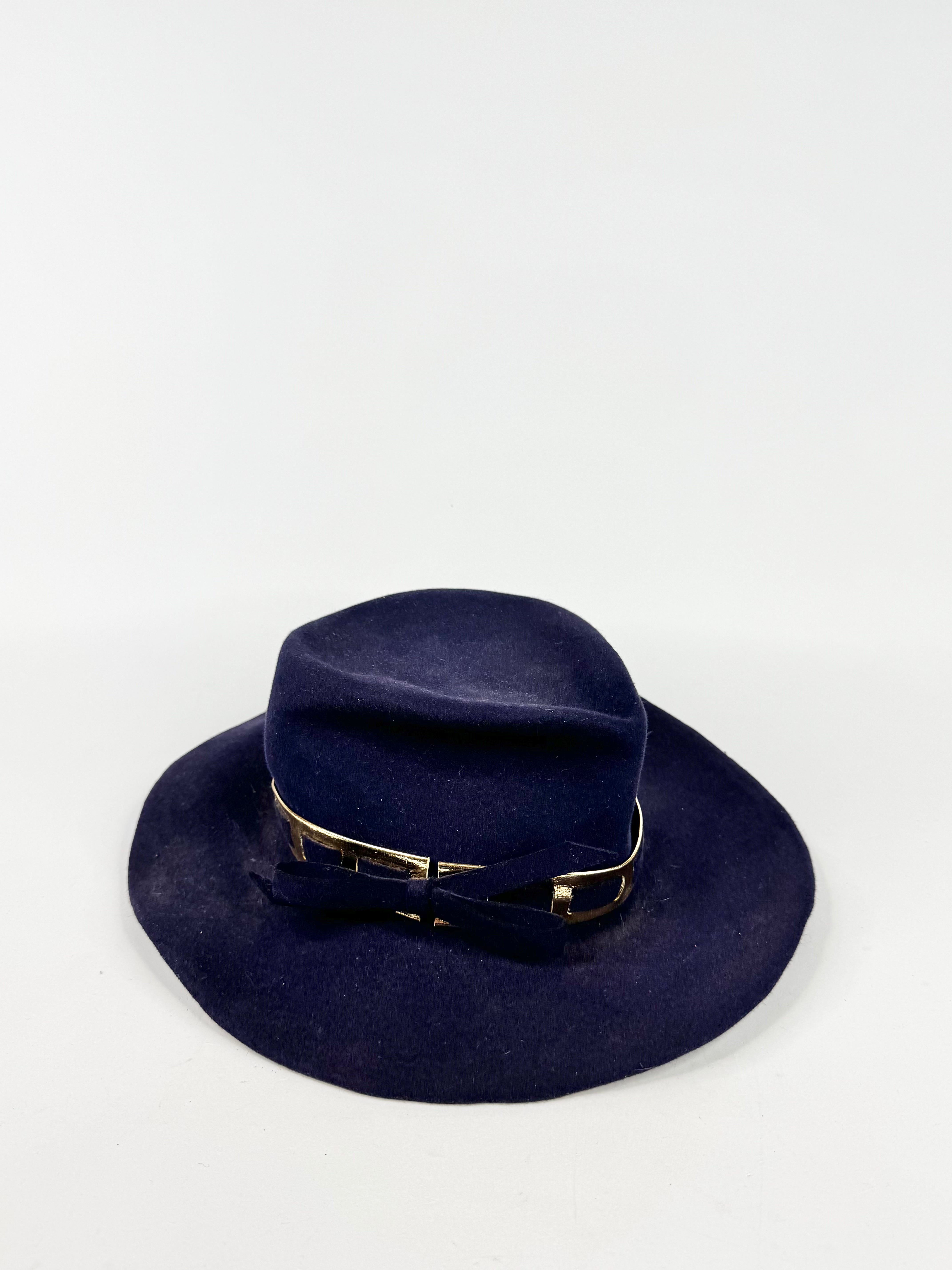 Navy blue hat with a gold band on a white background