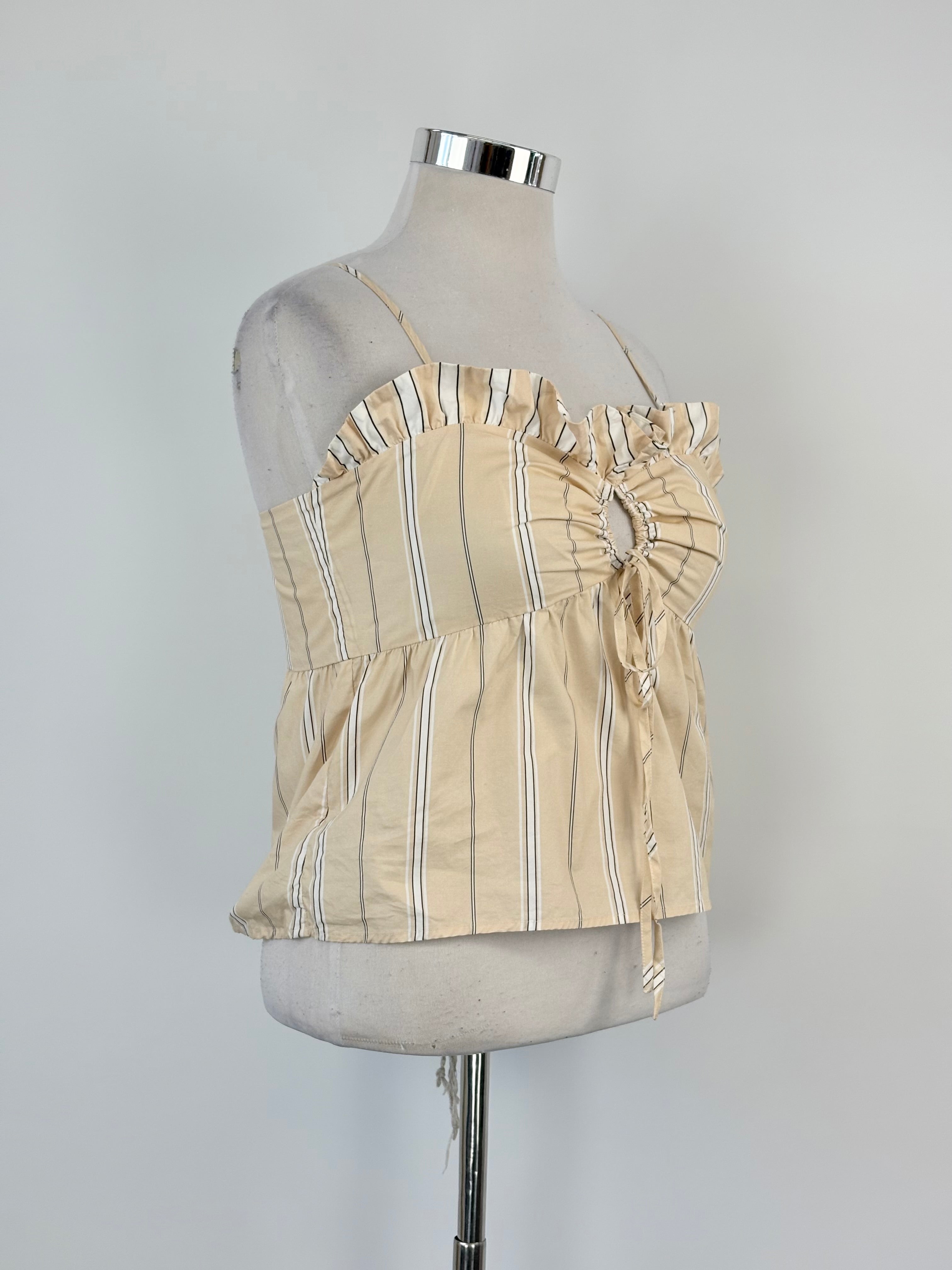 A beige striped cropped top with a ruffled bodice, displayed on a mannequin.