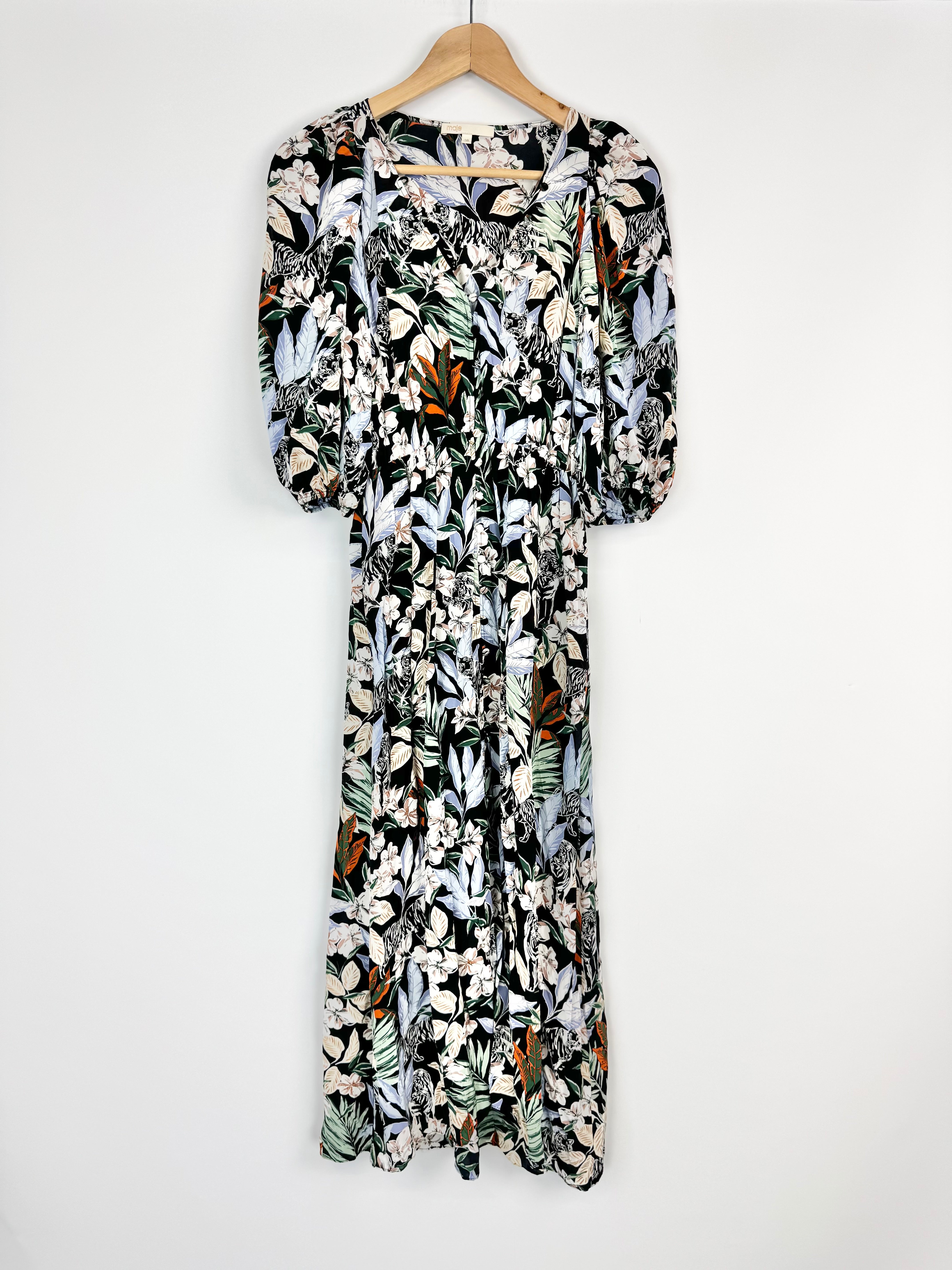 Floral patterned dress on a hanger against a white background