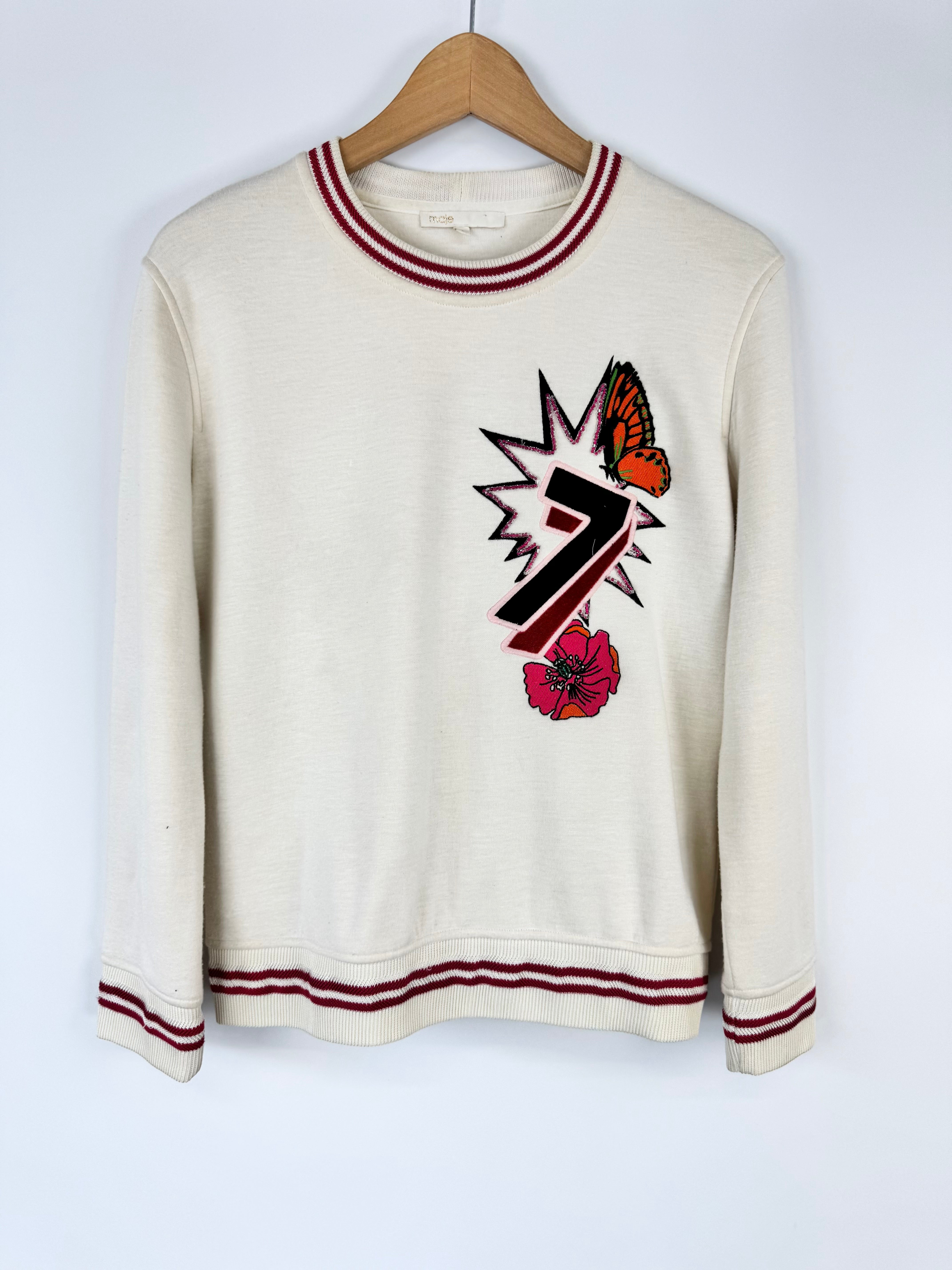 White sweatshirt with red trim featuring a graphic design on a white background