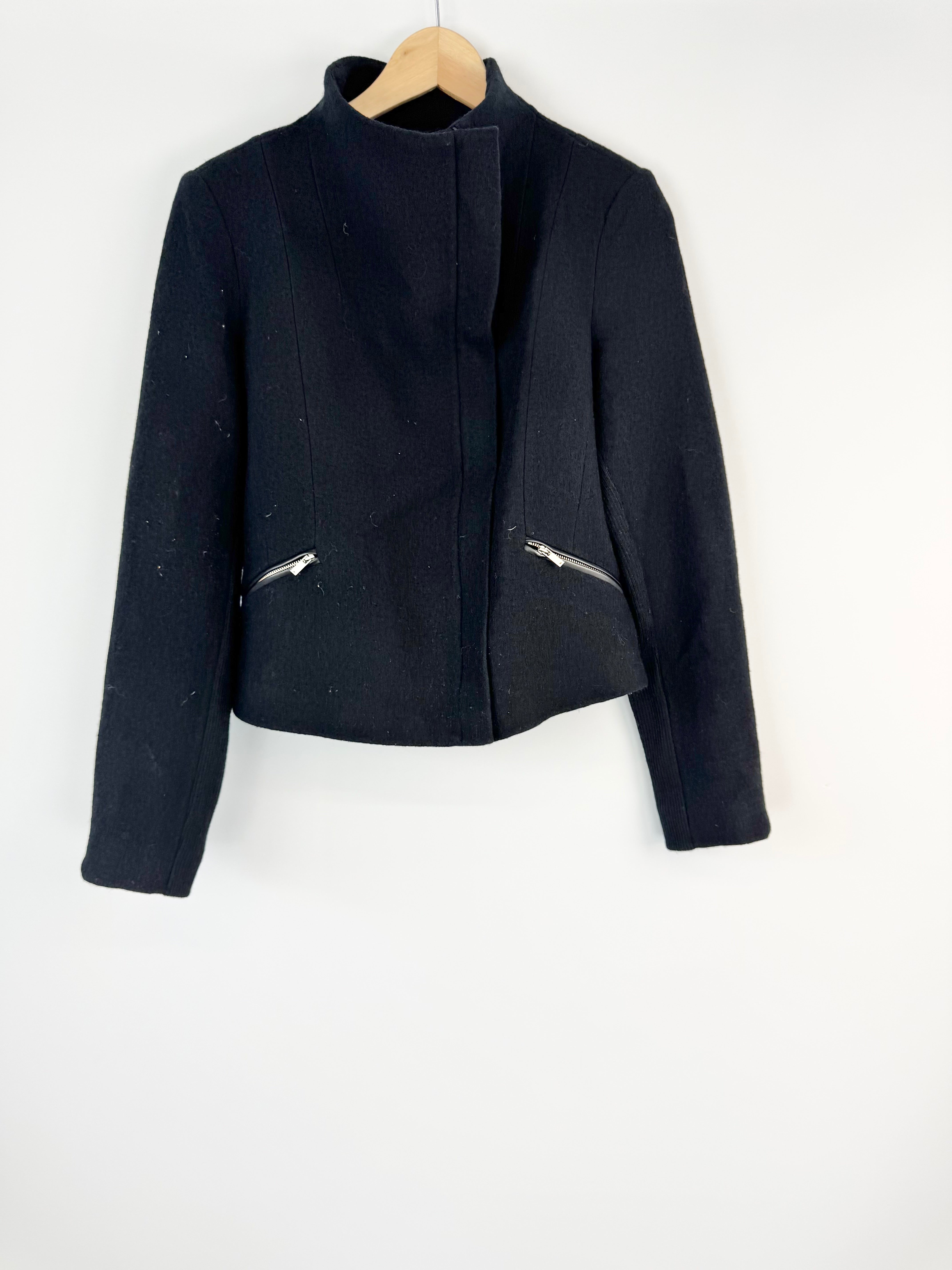 Black jacket on a hanger against a white background