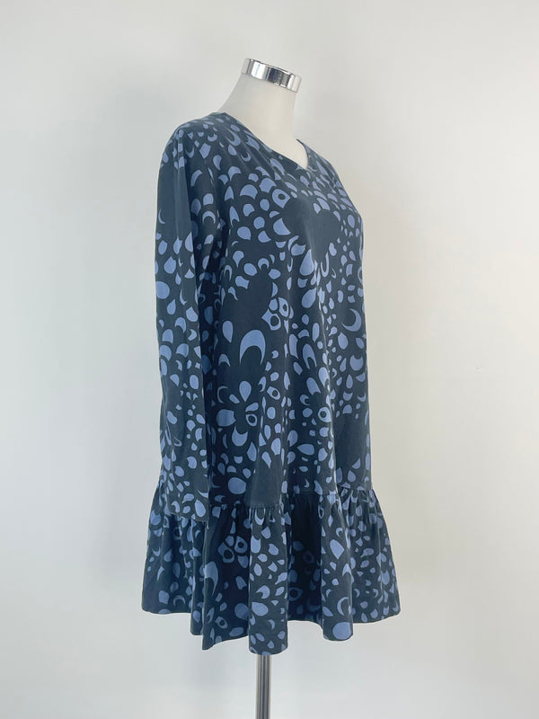 A navy and black floral patterned Marimekko dress on a mannequin, displaying long sleeves and a flared design.