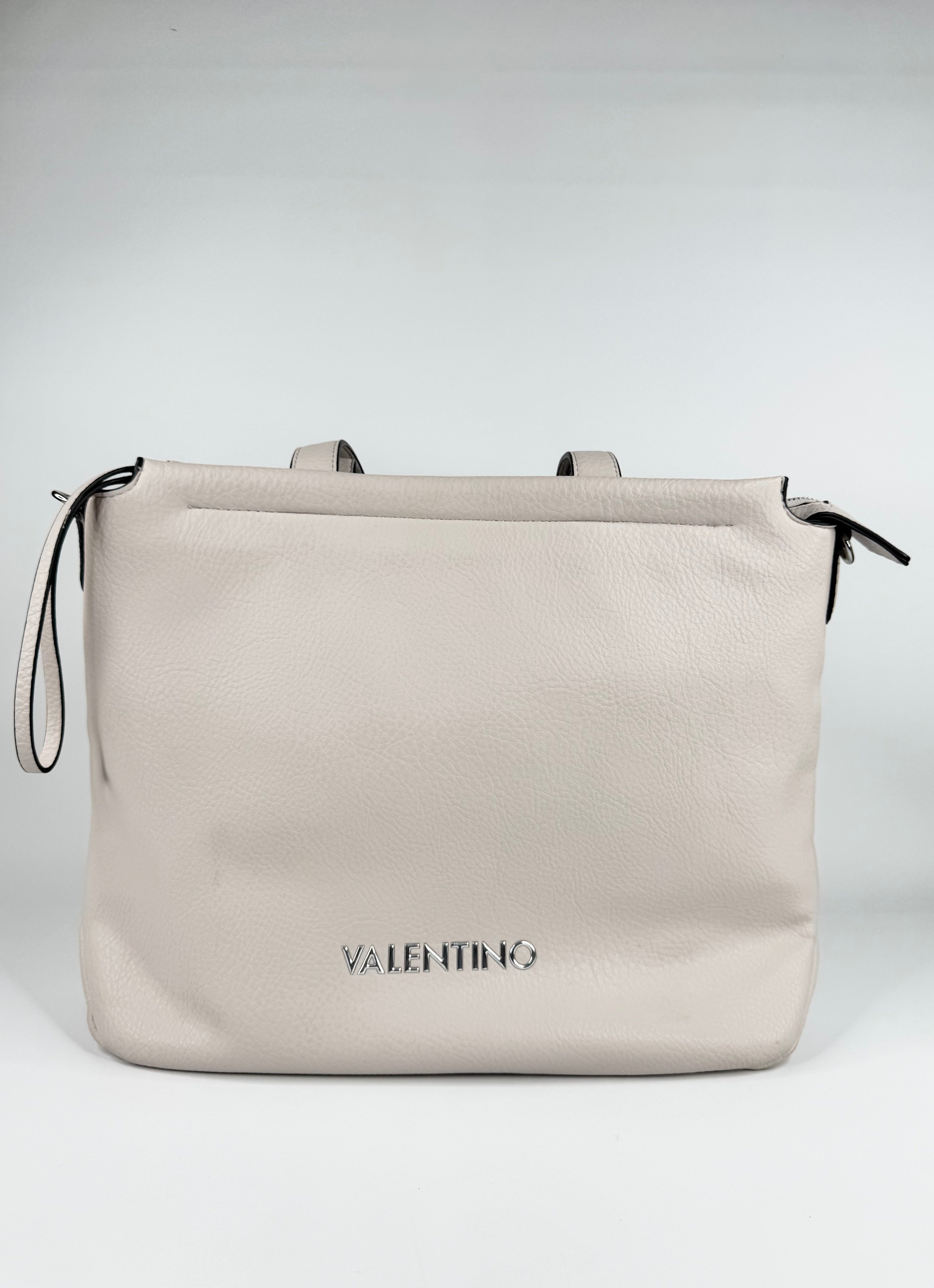 Beige handbag with 'Valentino' branding on a light gray background