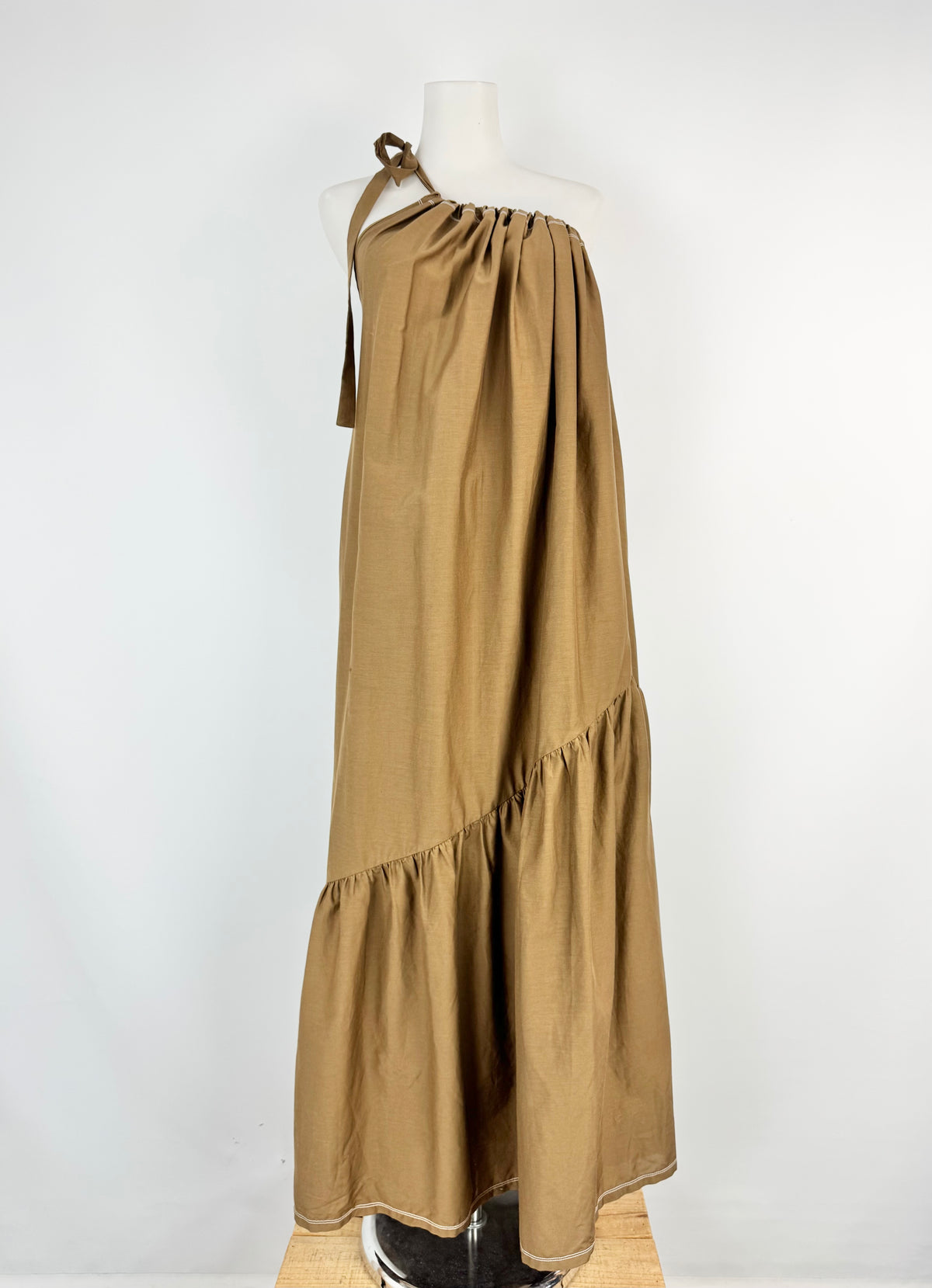 Brown halter neck dress on a mannequin against a white background