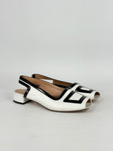 White and black open-toe shoes on a light gray background