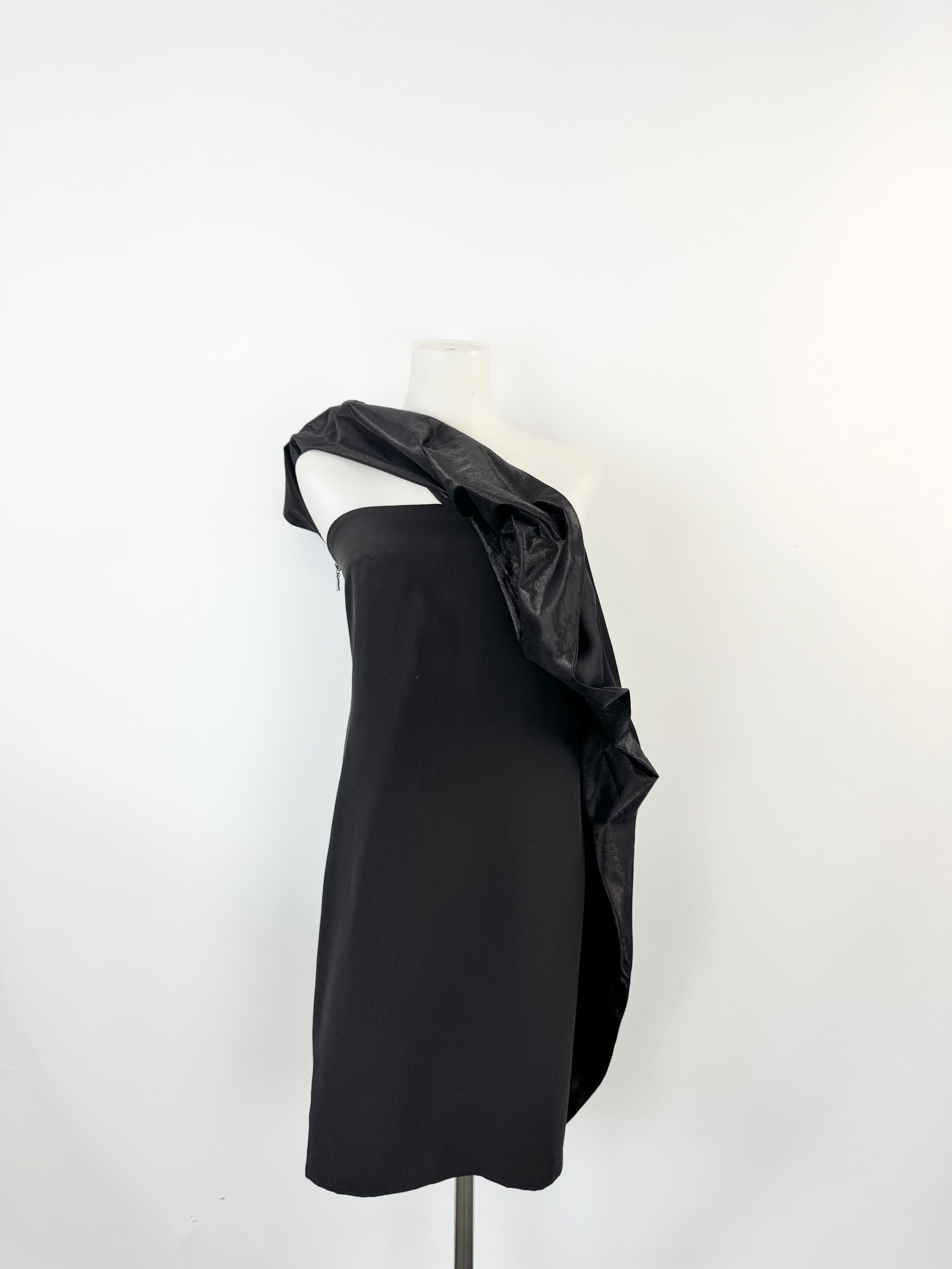 Black one-shoulder dress on a mannequin against a white background