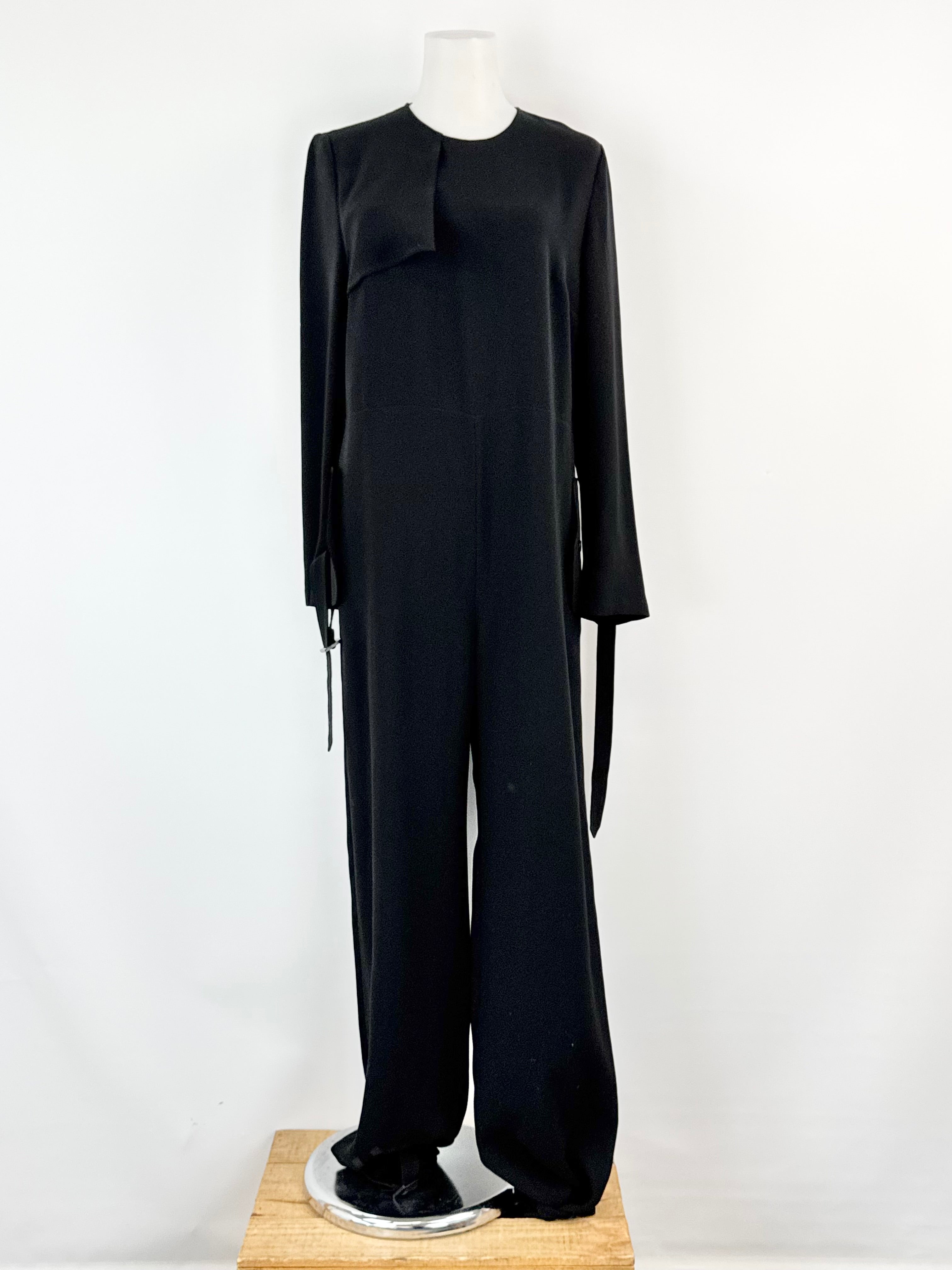 Black jumpsuit on a mannequin against a white background