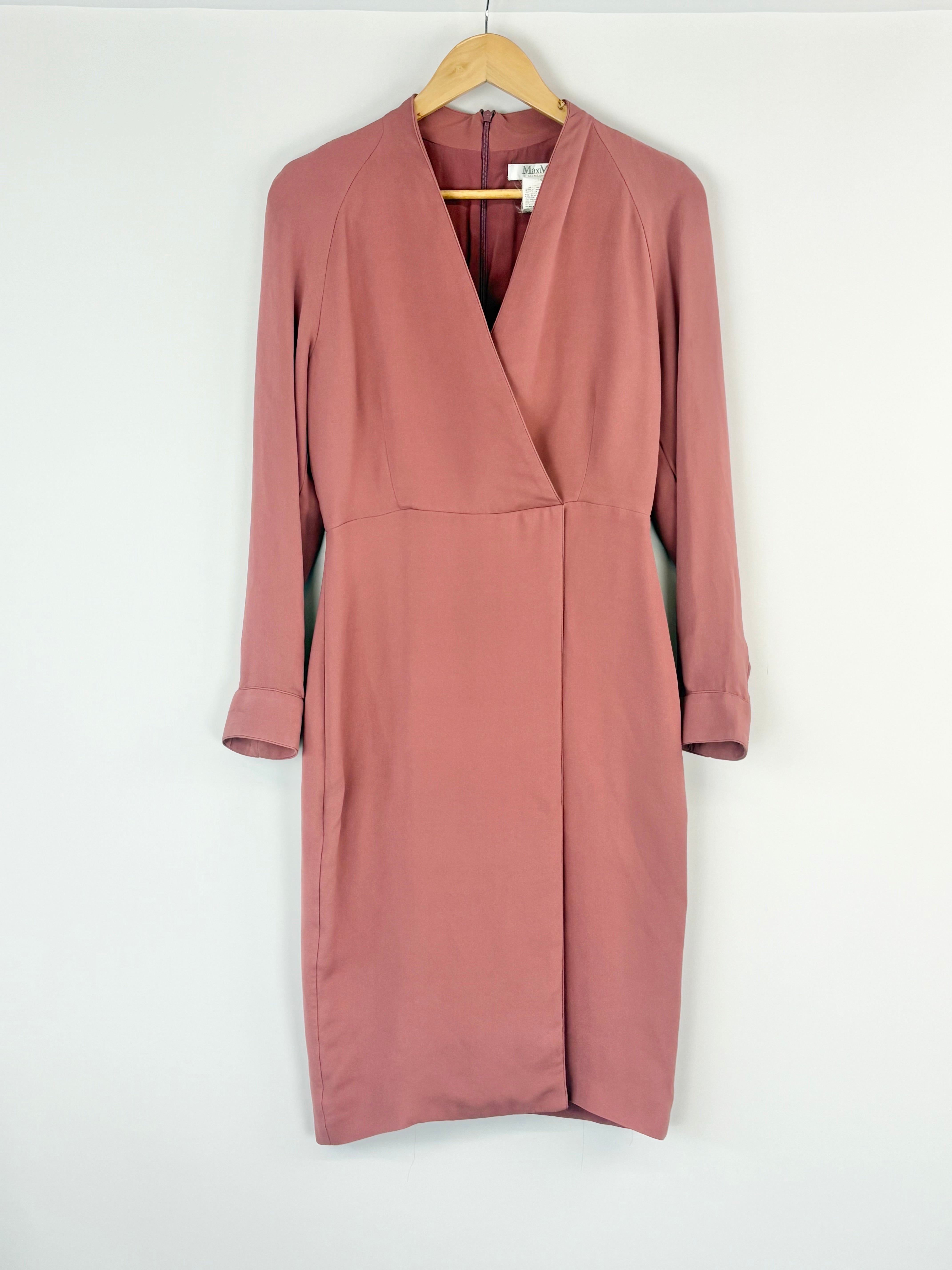 Pink dress on a hanger against a white background