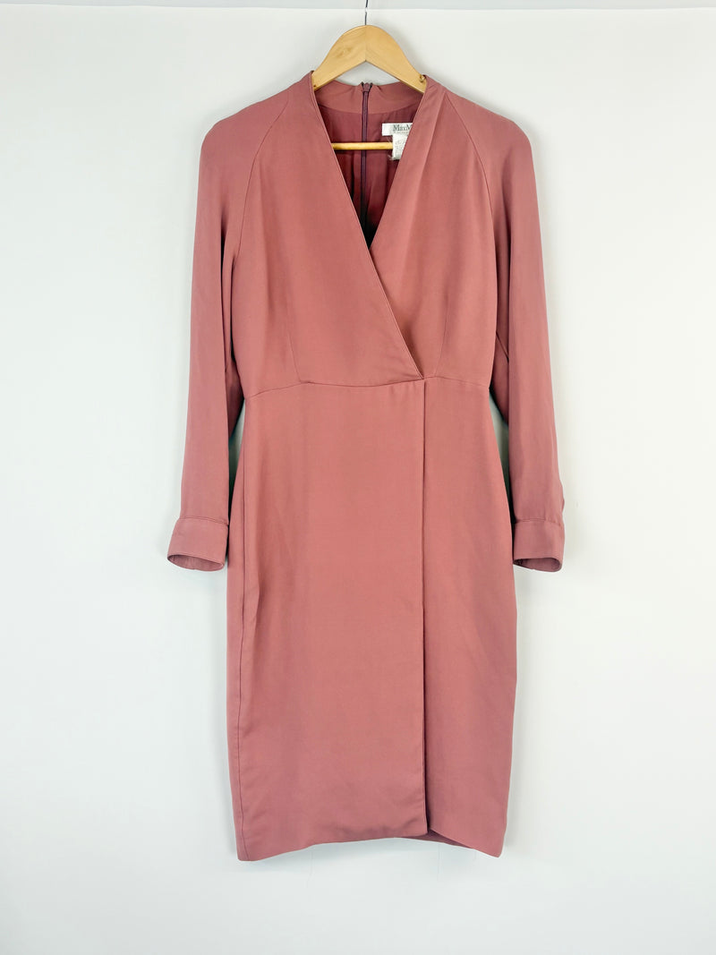 Pink dress on a hanger against a white background