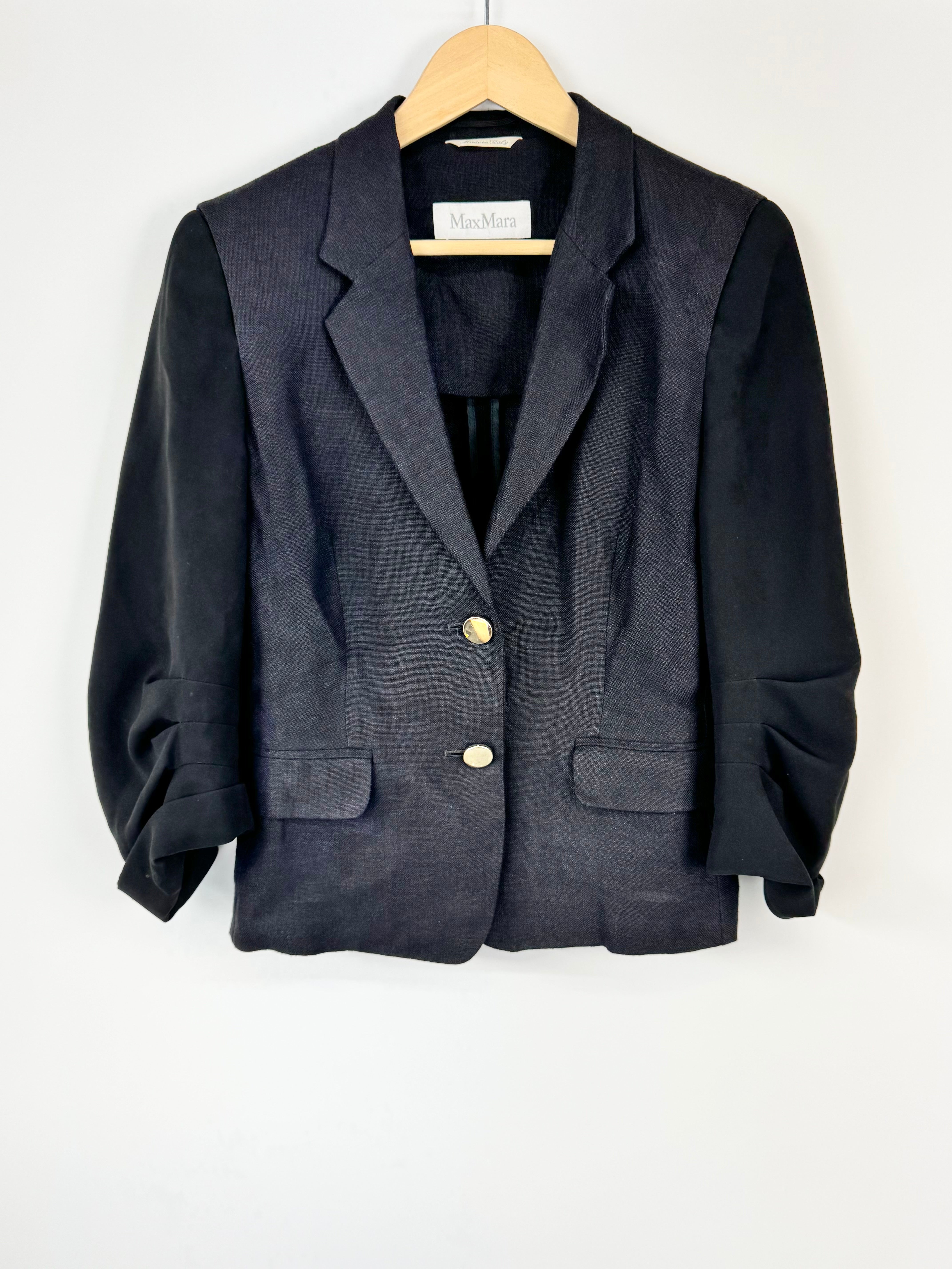 Black and Navy blazer on a hanger against a white background